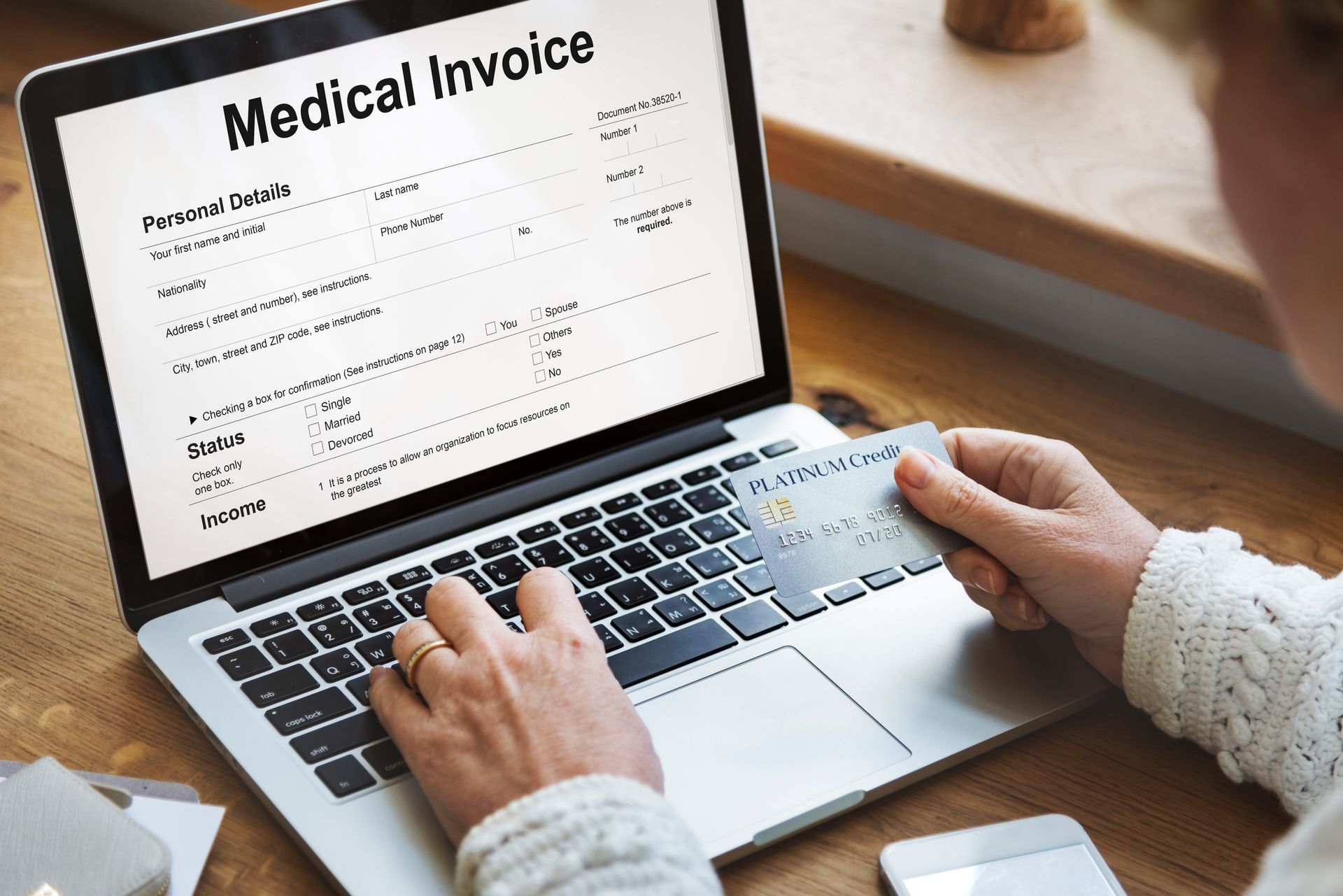 An elderly woman looking at a medical electronic invoice on a laptop screen.