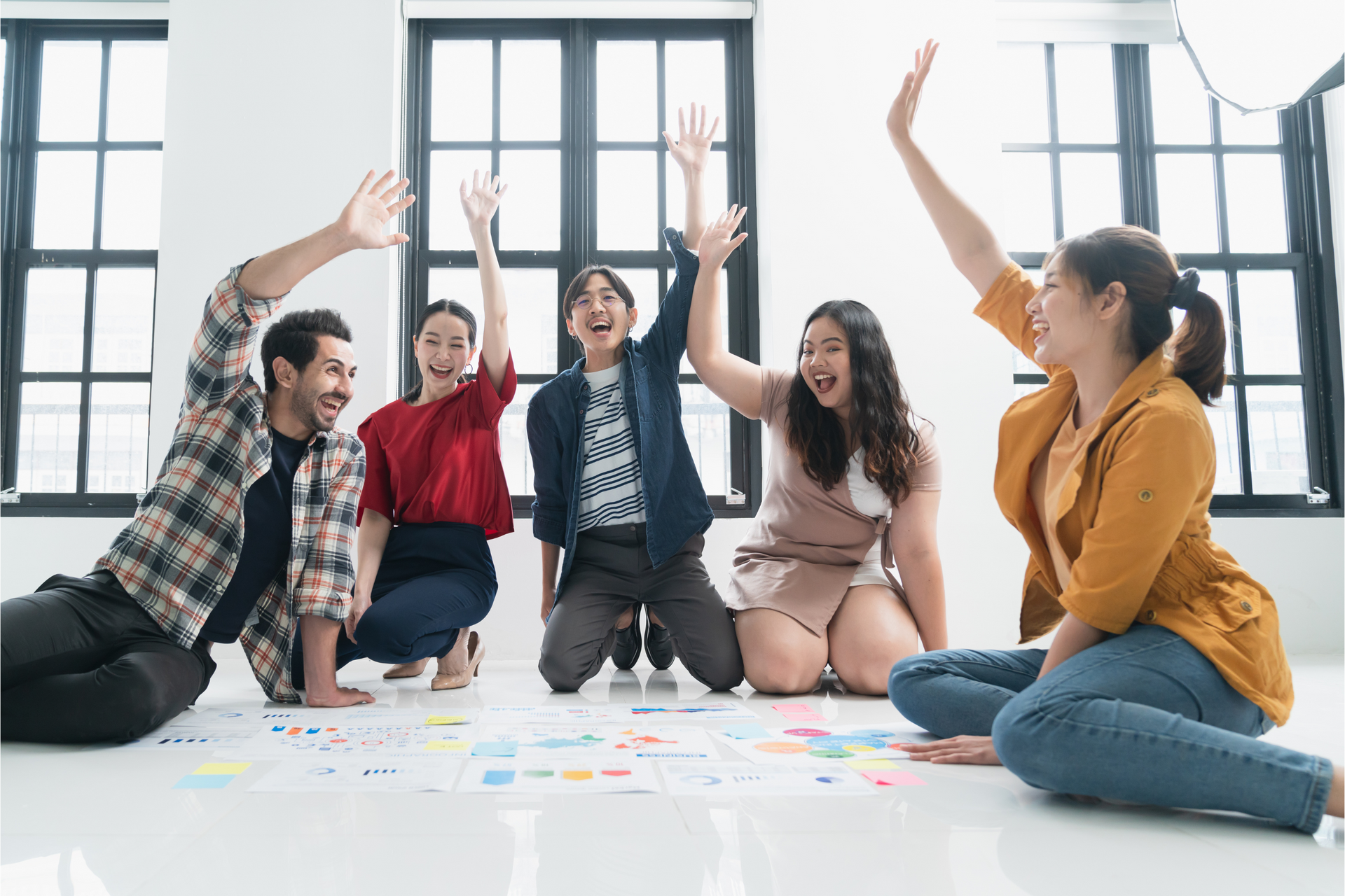 Group of five friends raising their hands while playing color dot game.