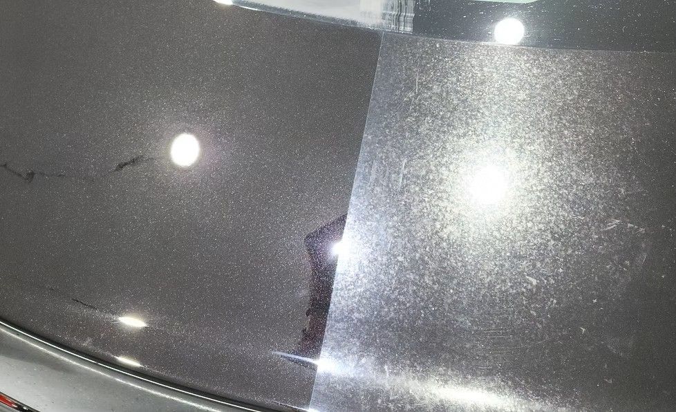 A car hood split in two showing before/after detailing. One side is dull, the other glossy grey.