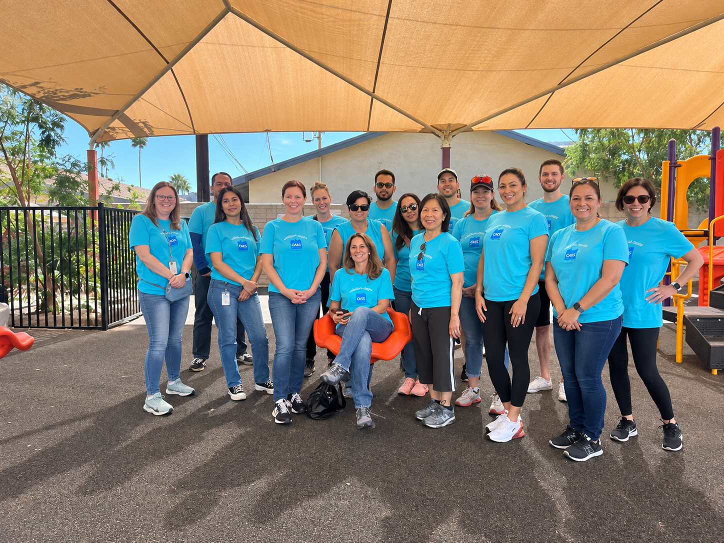 Group of diverse volunteers smiling with hands together in a park.