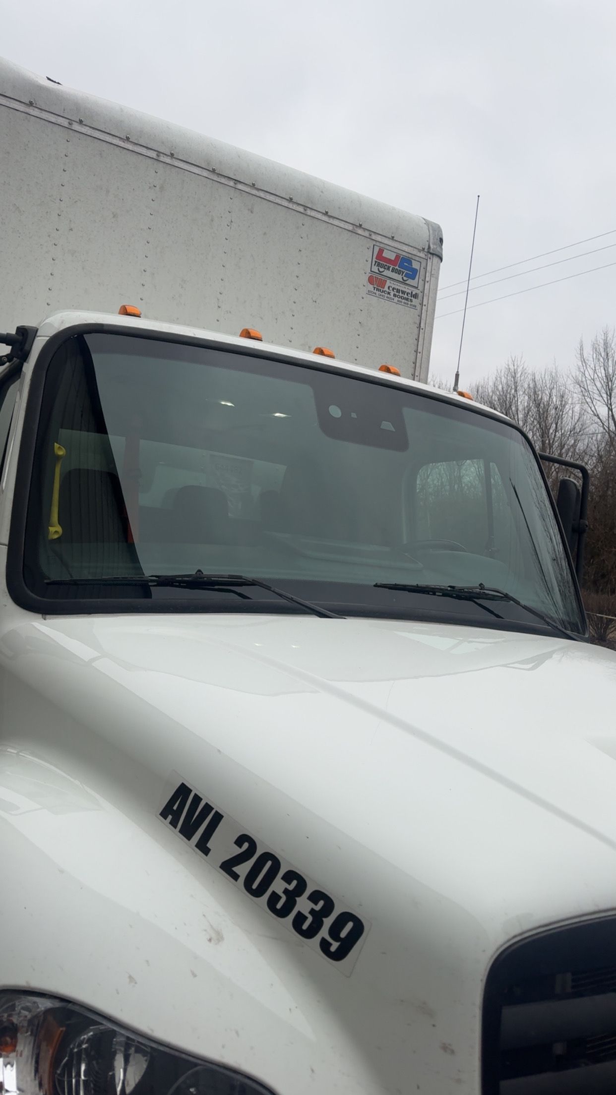 White box truck cab with number 208339 parked outdoors under an overcast sky
