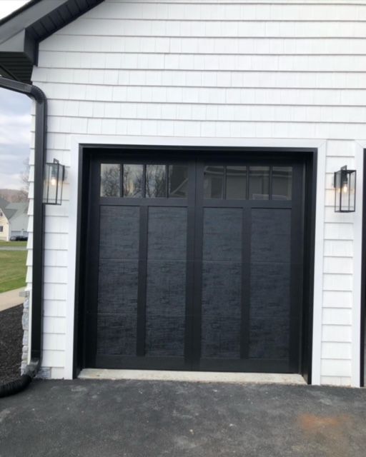 Paneled black garage door with windows