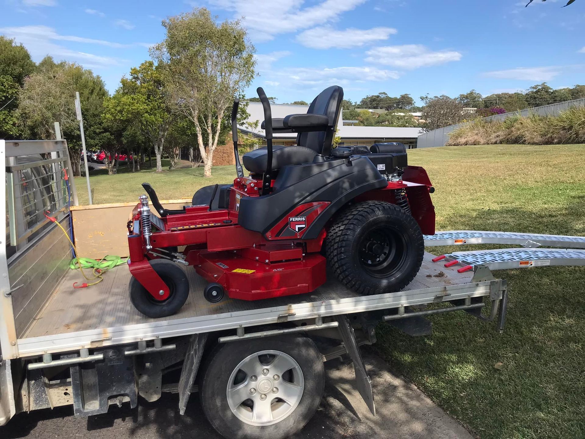 A Red Lawn Mower is Sitting on the Back of a Truck — Coffs Chainsaw and Mower in Urunga, NSW