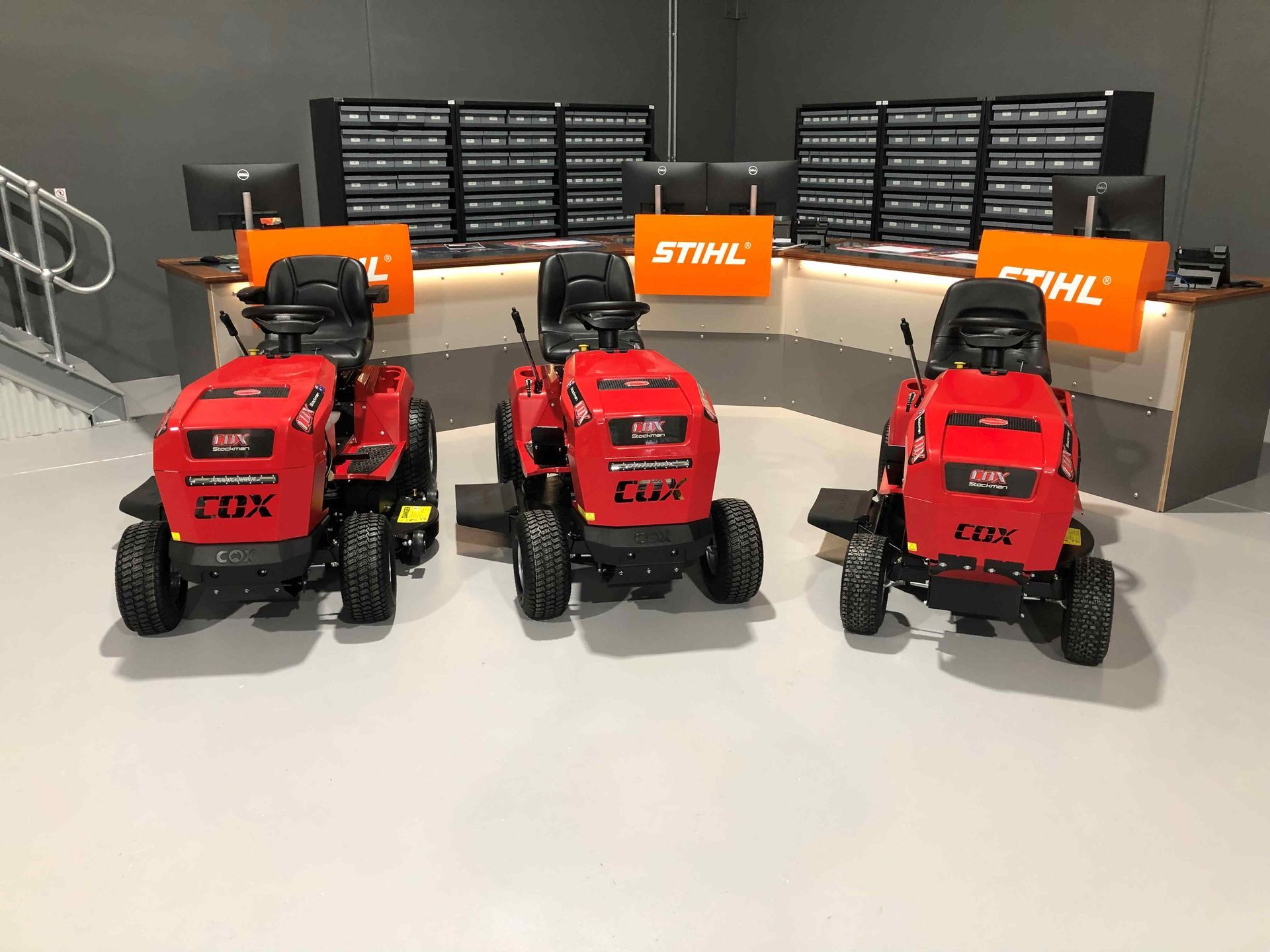 Three Red Lawn Mowers Are Parked Next to Each Other in a Store — Coffs Chainsaw and Mower in Coffs Harbour, NSW
