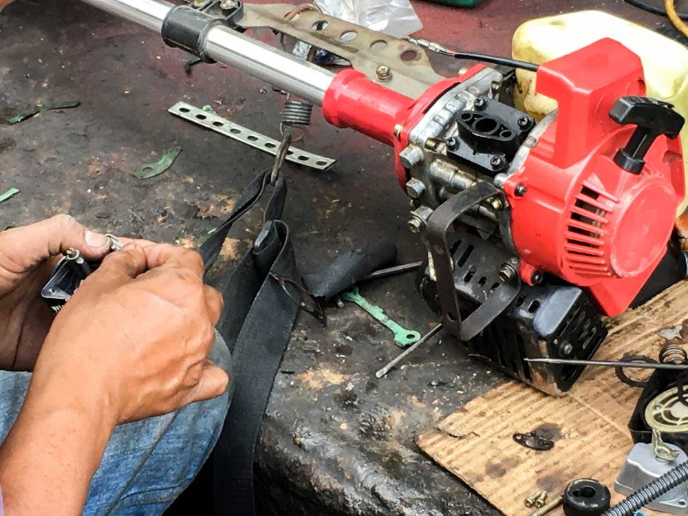 Repairman Fixes The Lawnmower With Tools — Coffs Chainsaw and Mower in Urunga, NSW