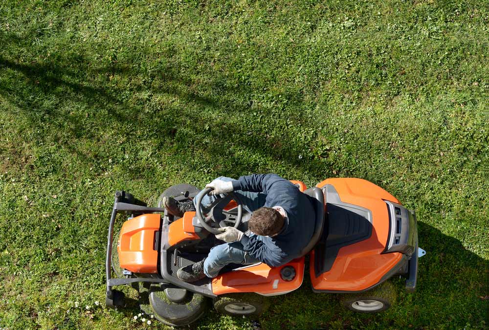 View From Above Of A Man Mowing A Lawn — Coffs Chainsaw and Mower in Macksville, NSW