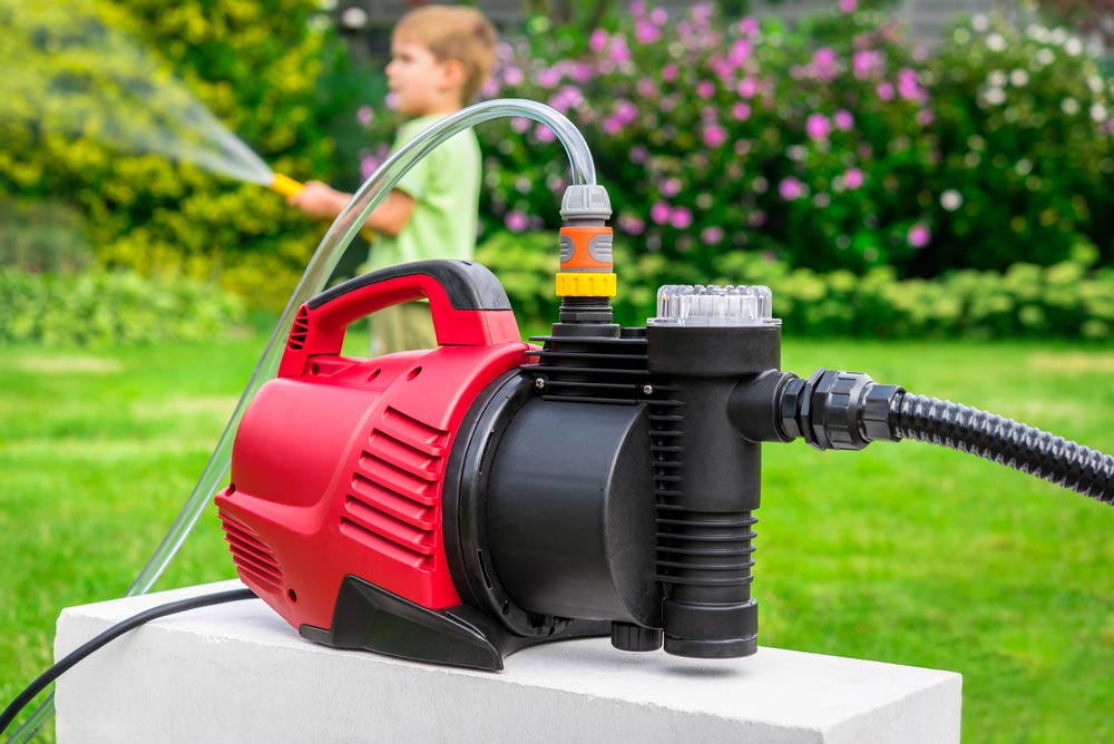 Water Pump Being Used In A Garden — Coffs Chainsaw and Mower in Macksville, NSW