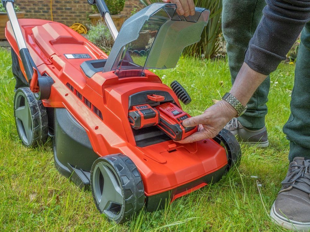 Gardener Changing The Battery On Lawnmower — Coffs Chainsaw and Mower in Kempsey, NSW