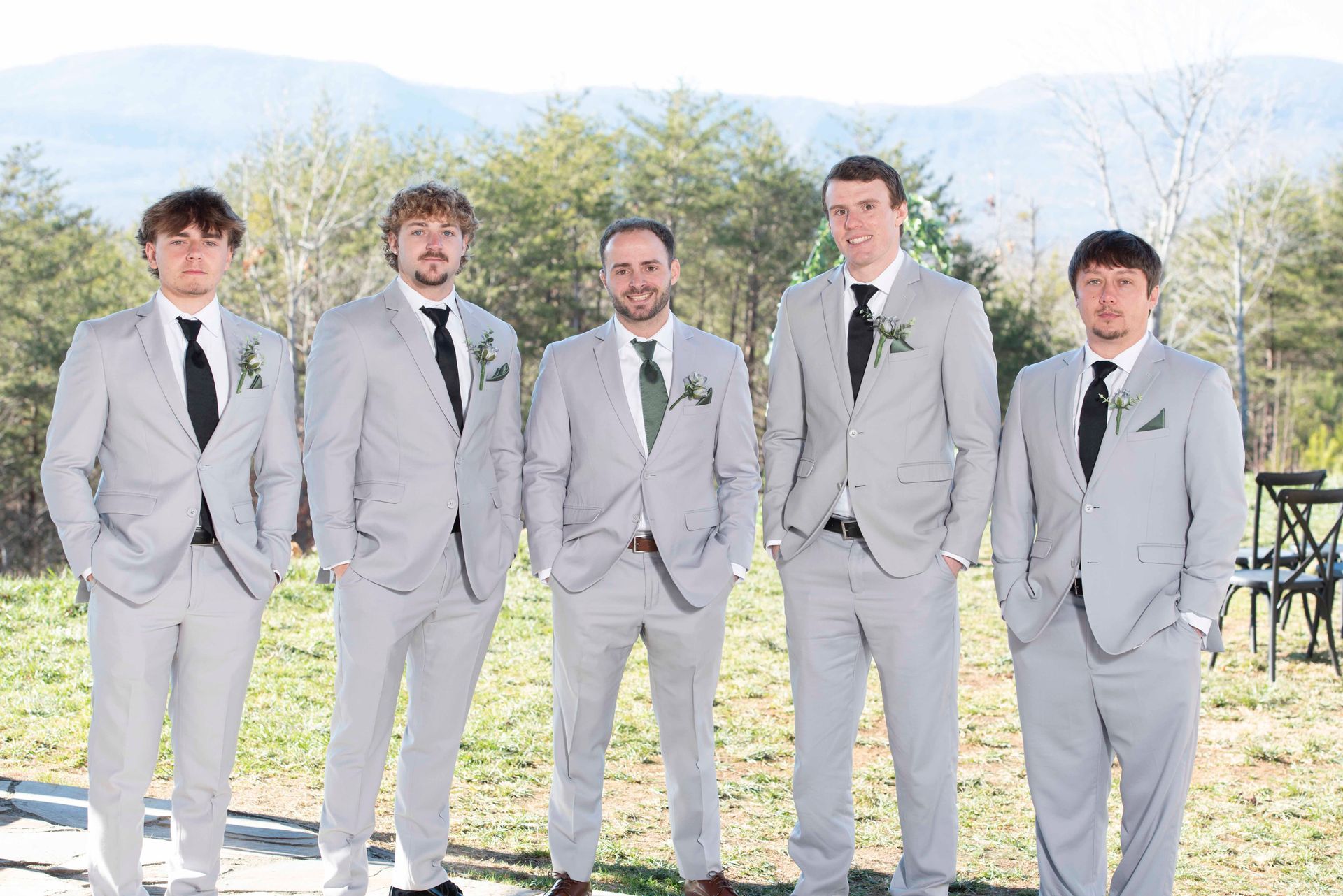 Groomsmen standing together outdoors before ceremony at mountain wedding venue