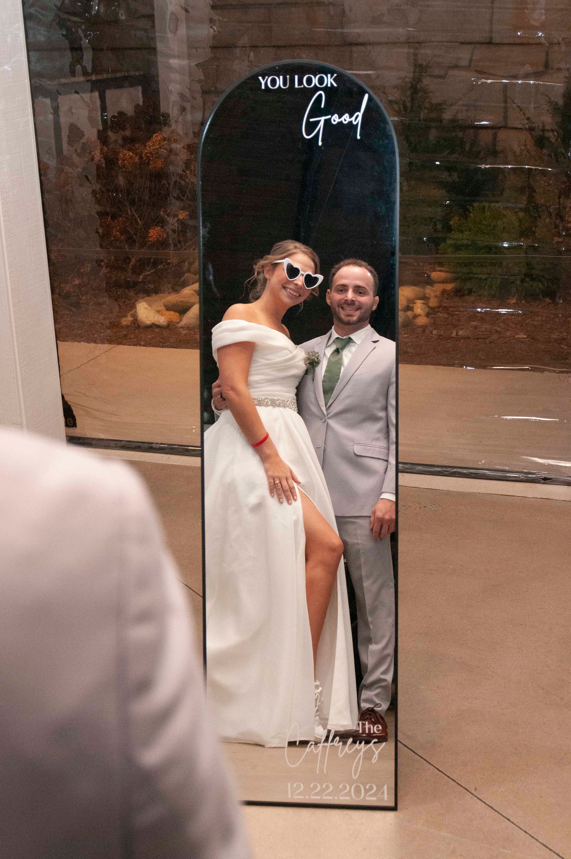Bride and groom reflected in mirror during getting ready moments at wedding weekend venue