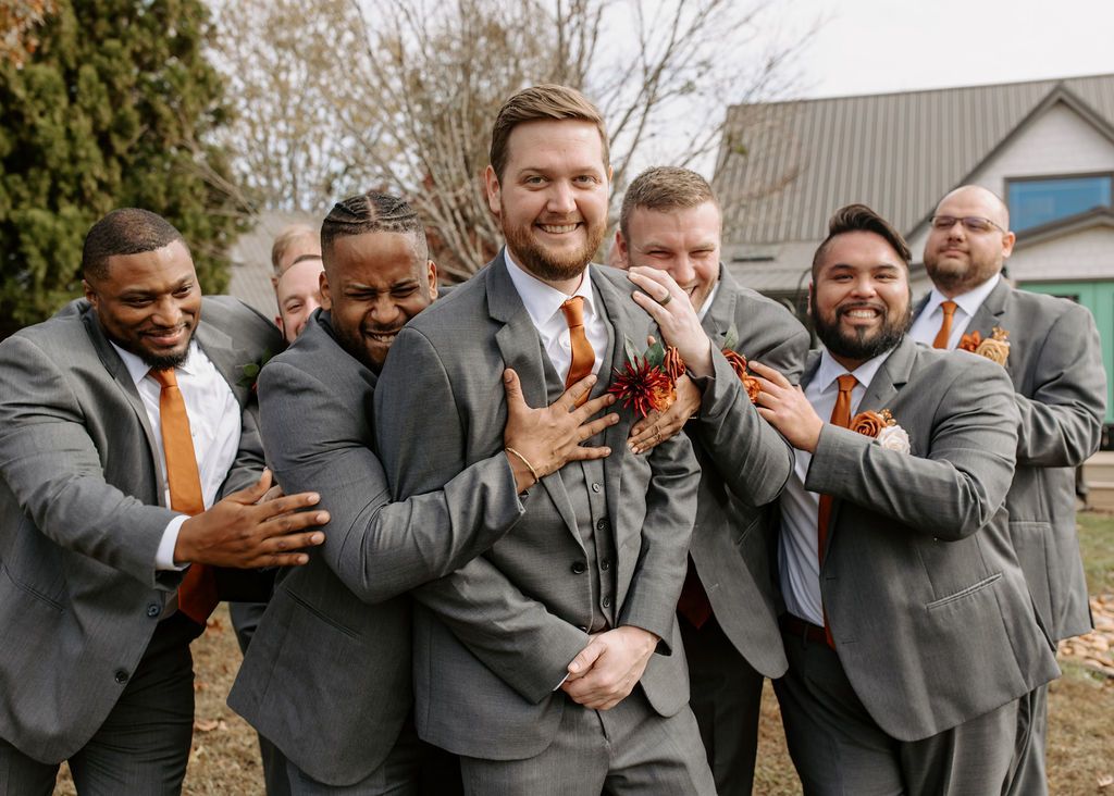 Groom laughing with groomsmen before outdoor wedding ceremony in the North Carolina mountains