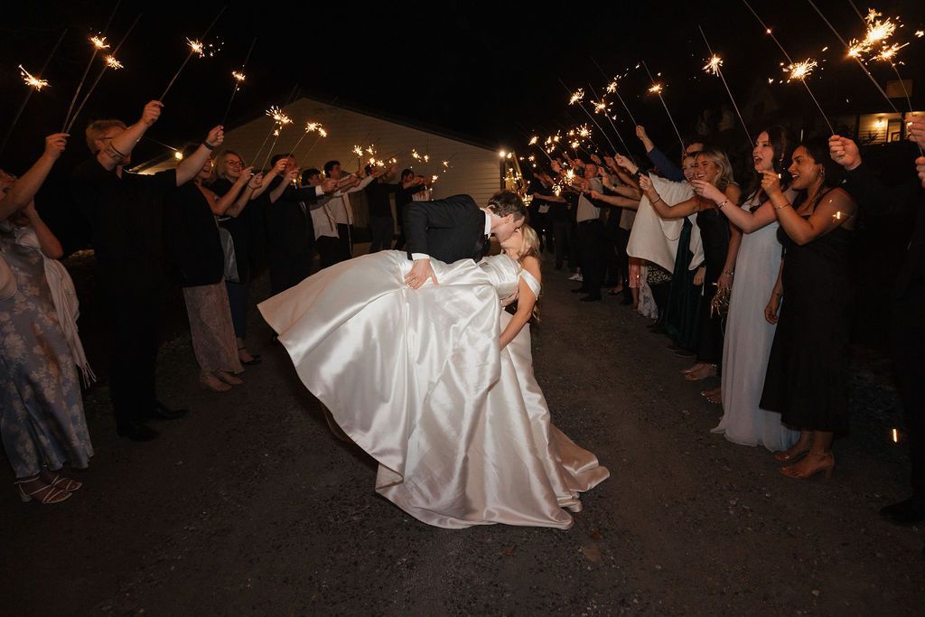 Bride twirling on dance floor during evening wedding reception celebration in open-air pavilion