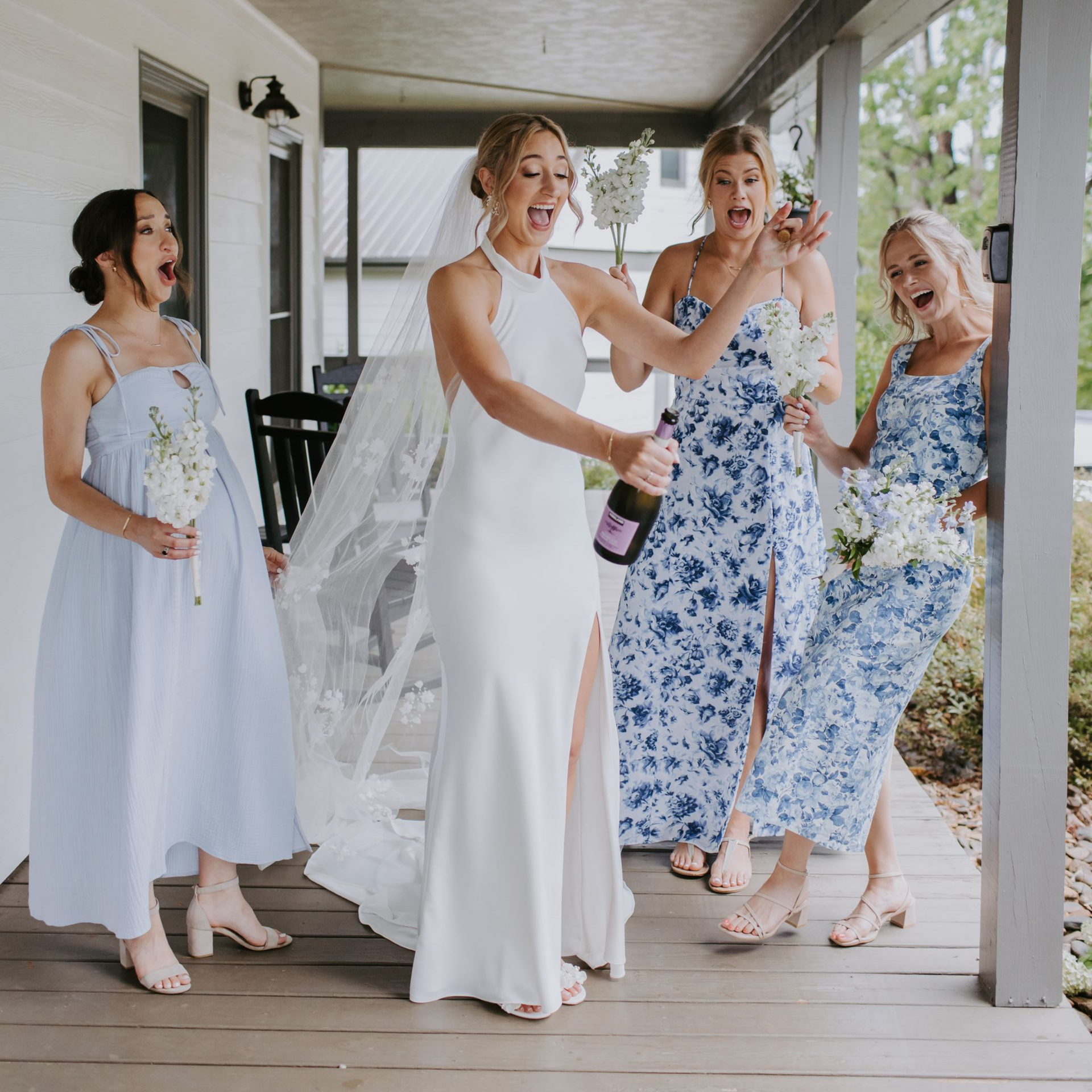 Bride popping champagne at Hilltop House during a wedding weekend at Serenity Ridge