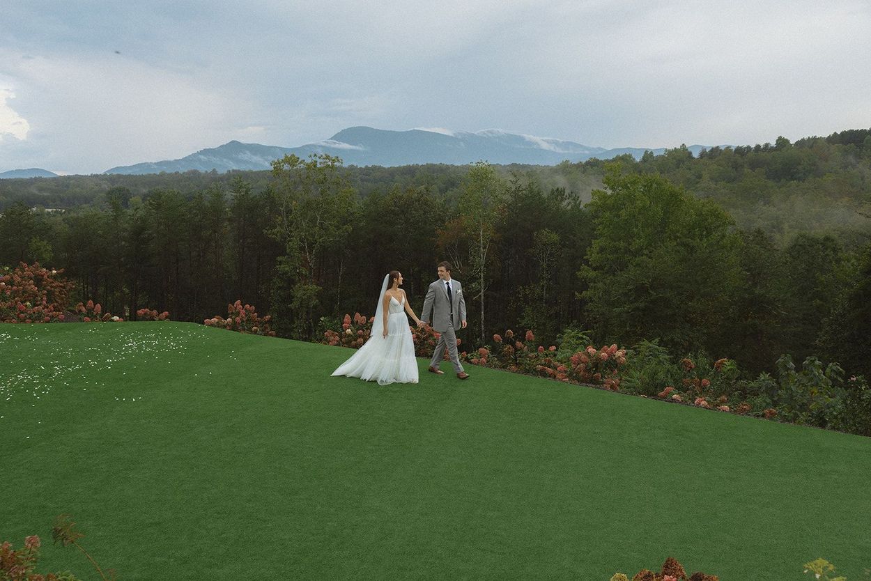 Couple walking the Serenity Ridge ceremony lawn after dinner with mountains as their backdrop