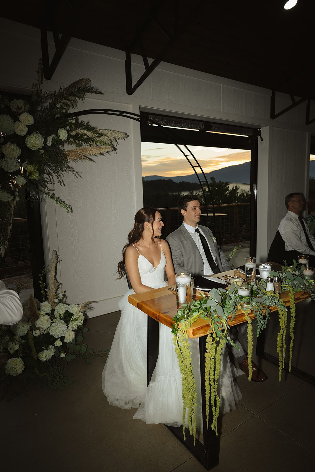 Bride at bar during cocktail hour inside open-air pavilion at Blue Ridge wedding venue