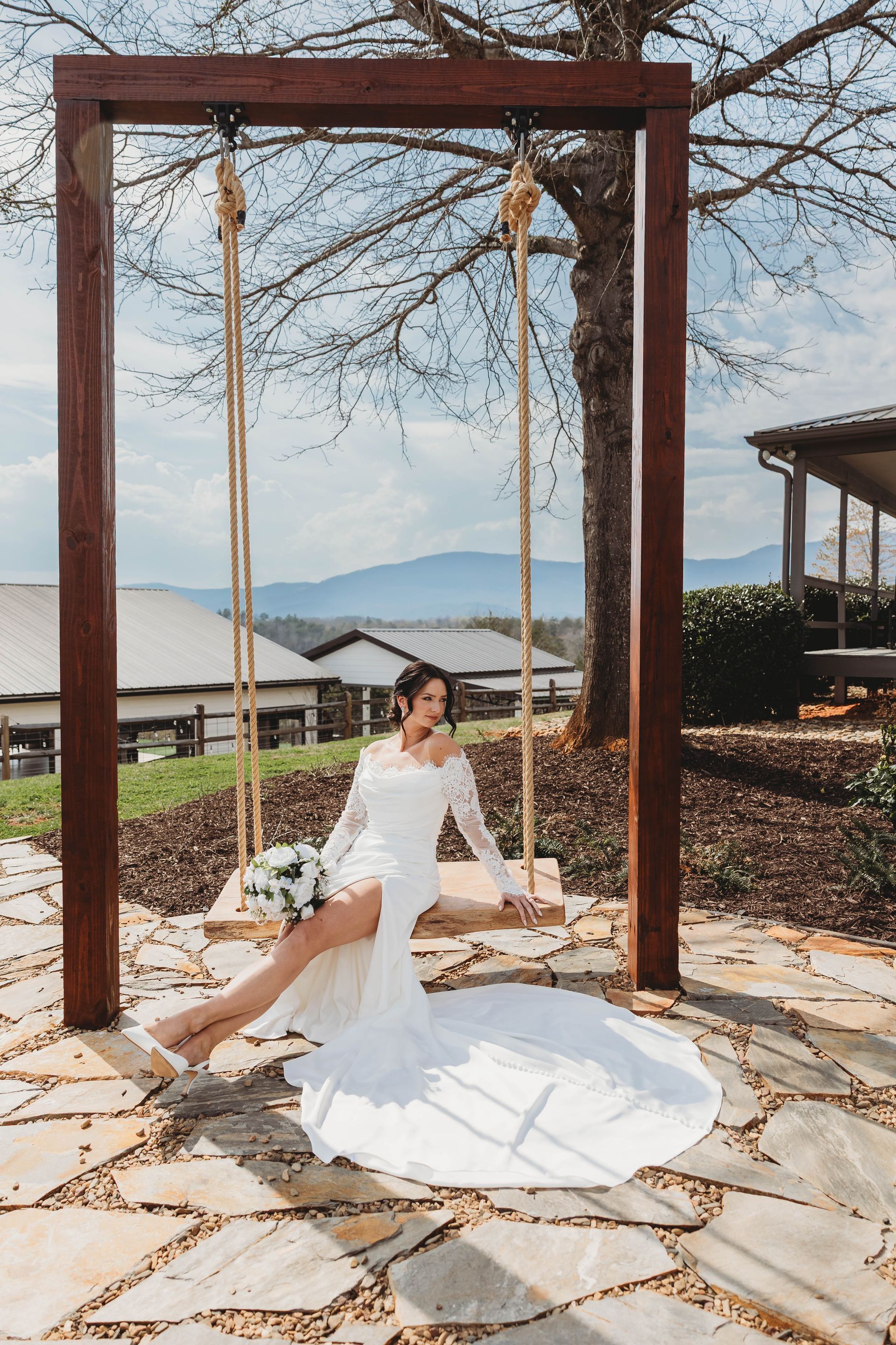 Bride on wooden swing with Blue Ridge mountain views at North Carolina venue