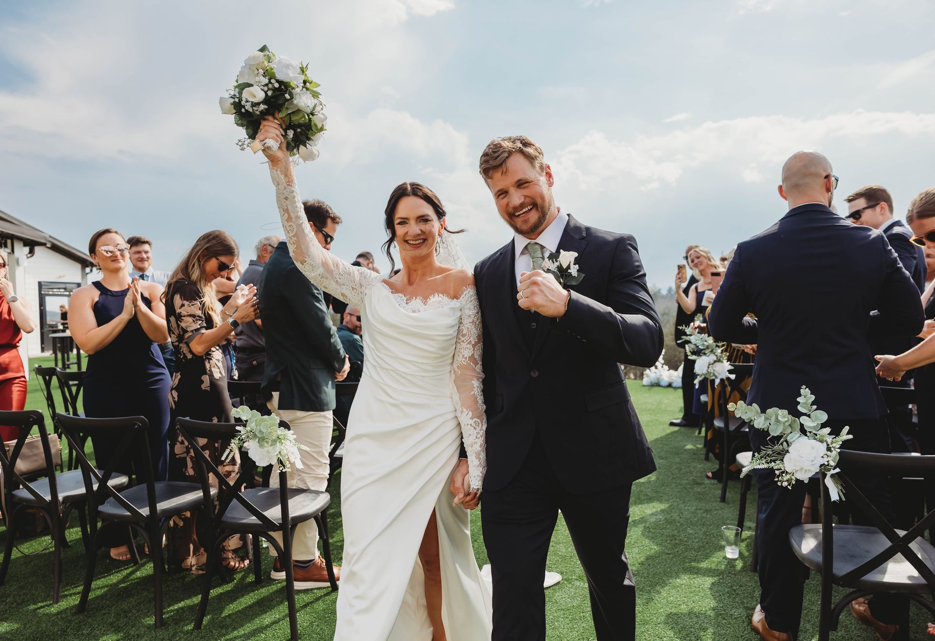Newlywed couple celebrating down the aisle during outdoor mountain wedding ceremony in WNC