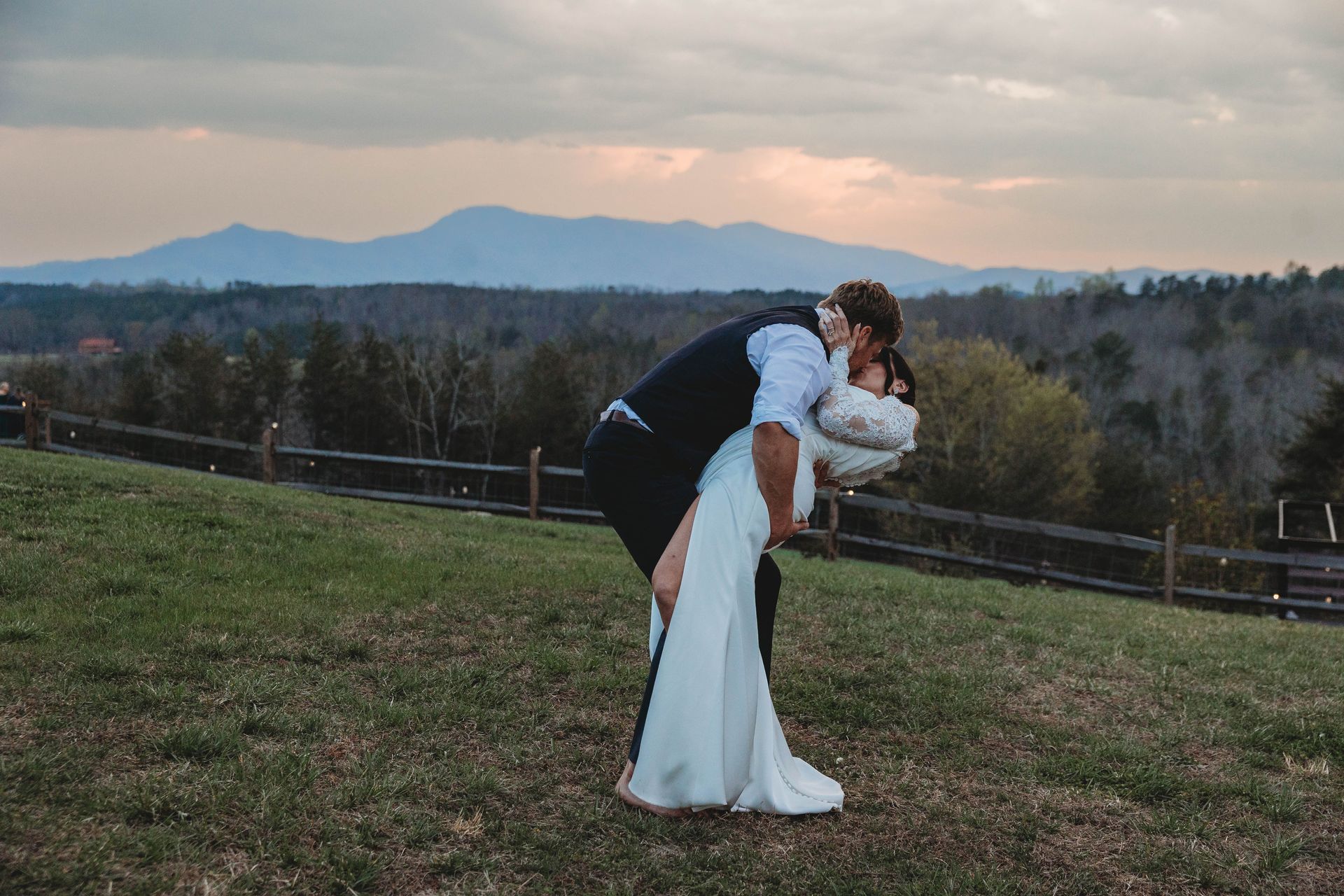 Bride and groom sharing a kiss overlooking mountain views during sunset wedding portrait session