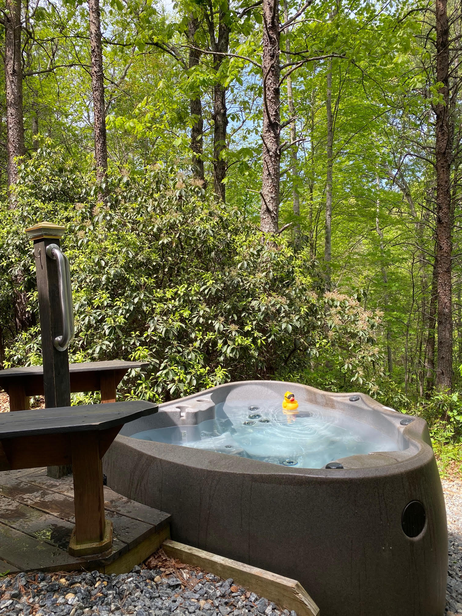 Private hot tub overlooking forest at Serenity Ridge cabin for wedding guest lodging
