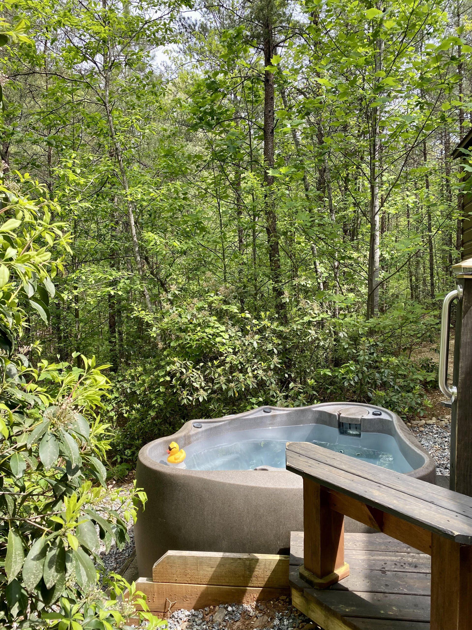 Private hot tub at Cabin B surrounded by forest at Serenity Ridge