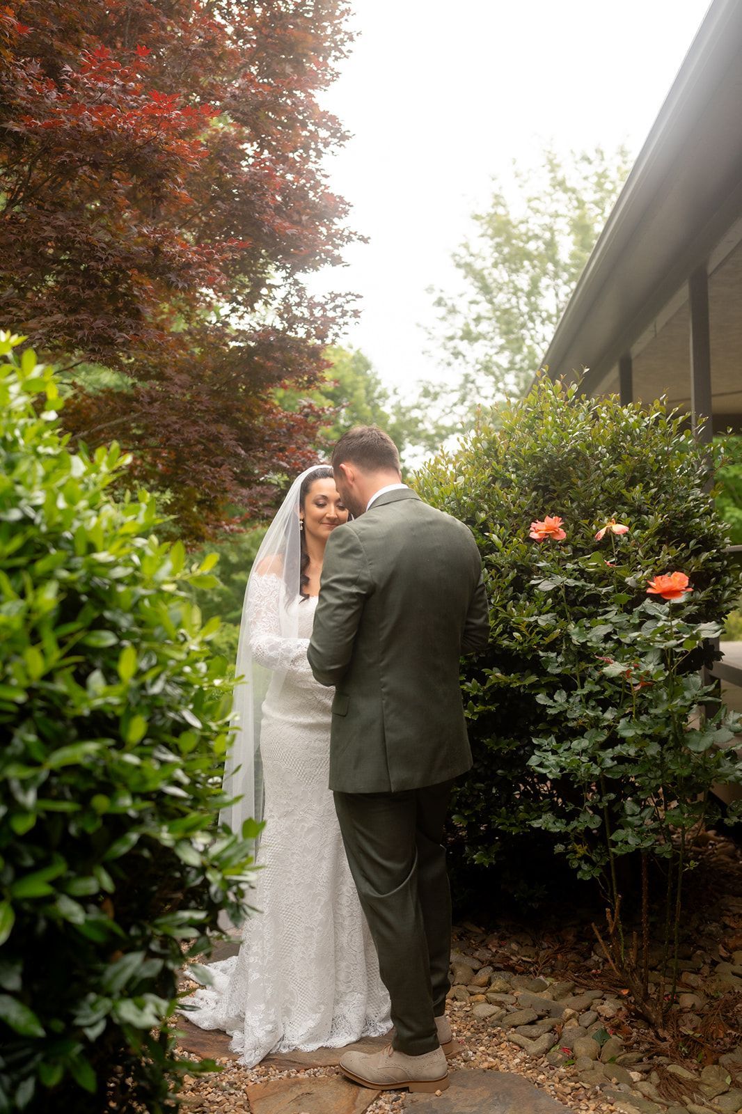 Bride and groom sharing quiet moment beside garden blooms at North Carolina mountain wedding venue