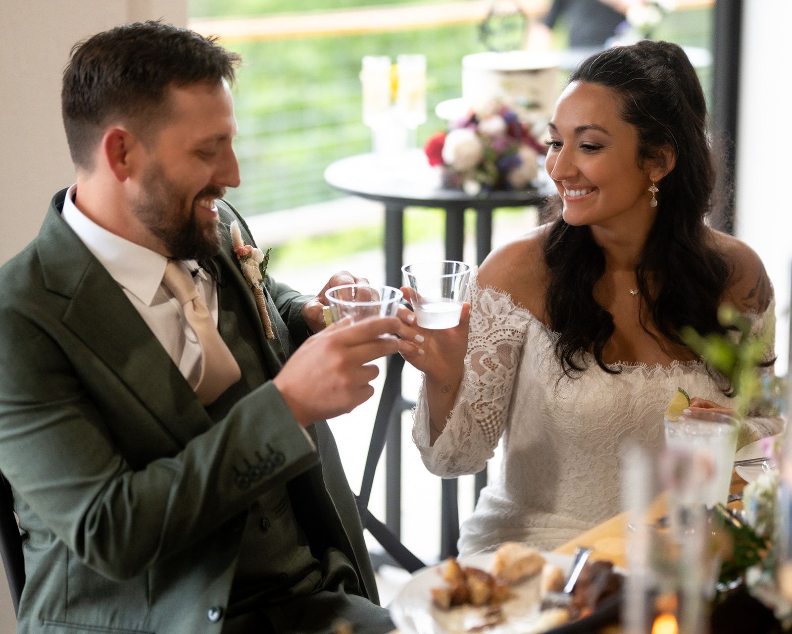 Bride and groom sharing toast during intimate wedding reception dinner in open-air pavilion