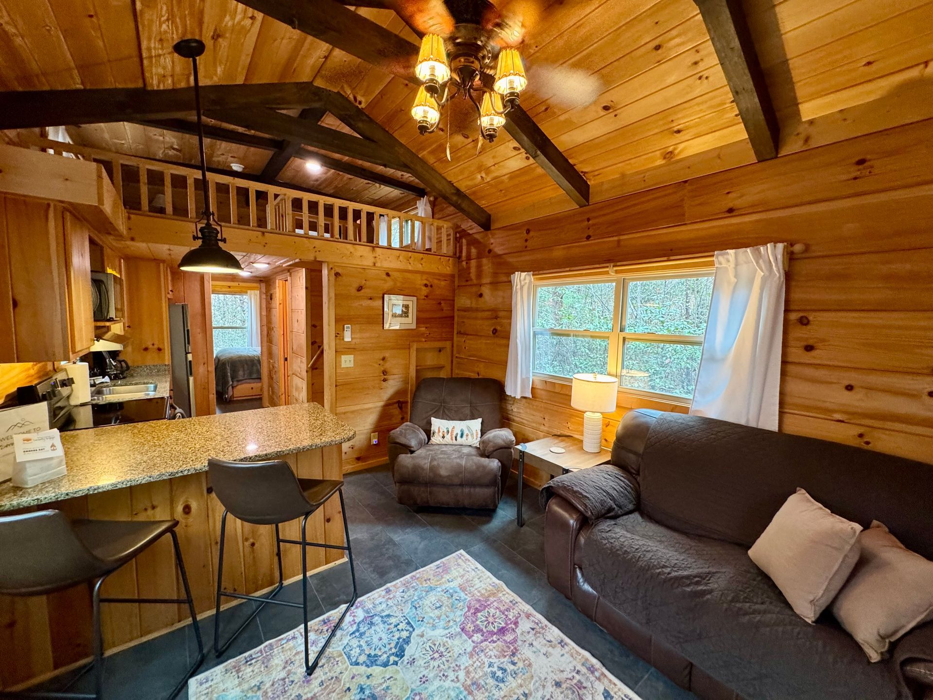 Living room with loveseat and recliner in Cabin B at Serenity Ridge wedding lodging