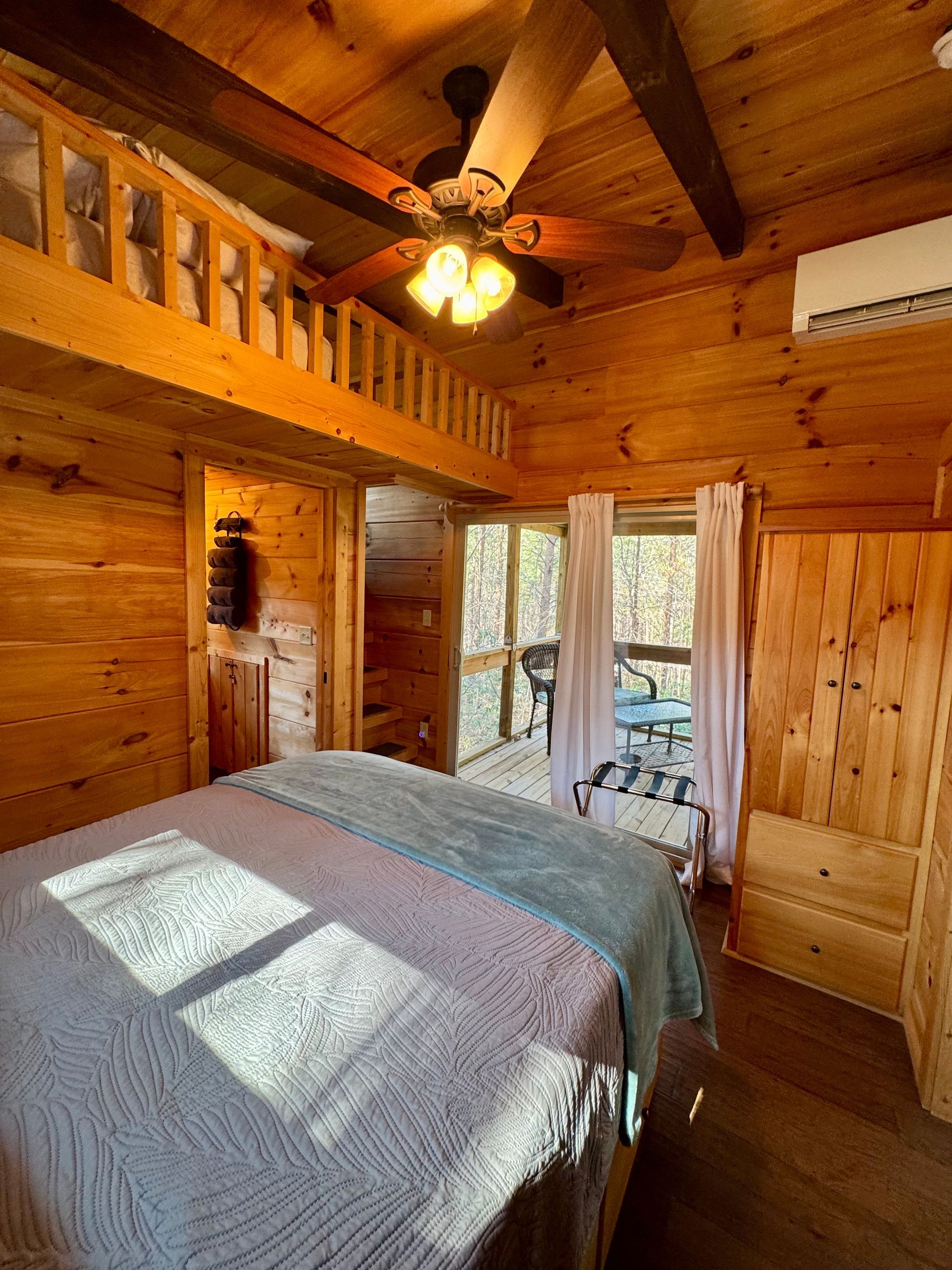 Main bedroom in Cabin A with sliding door to screened porch at Serenity Ridge