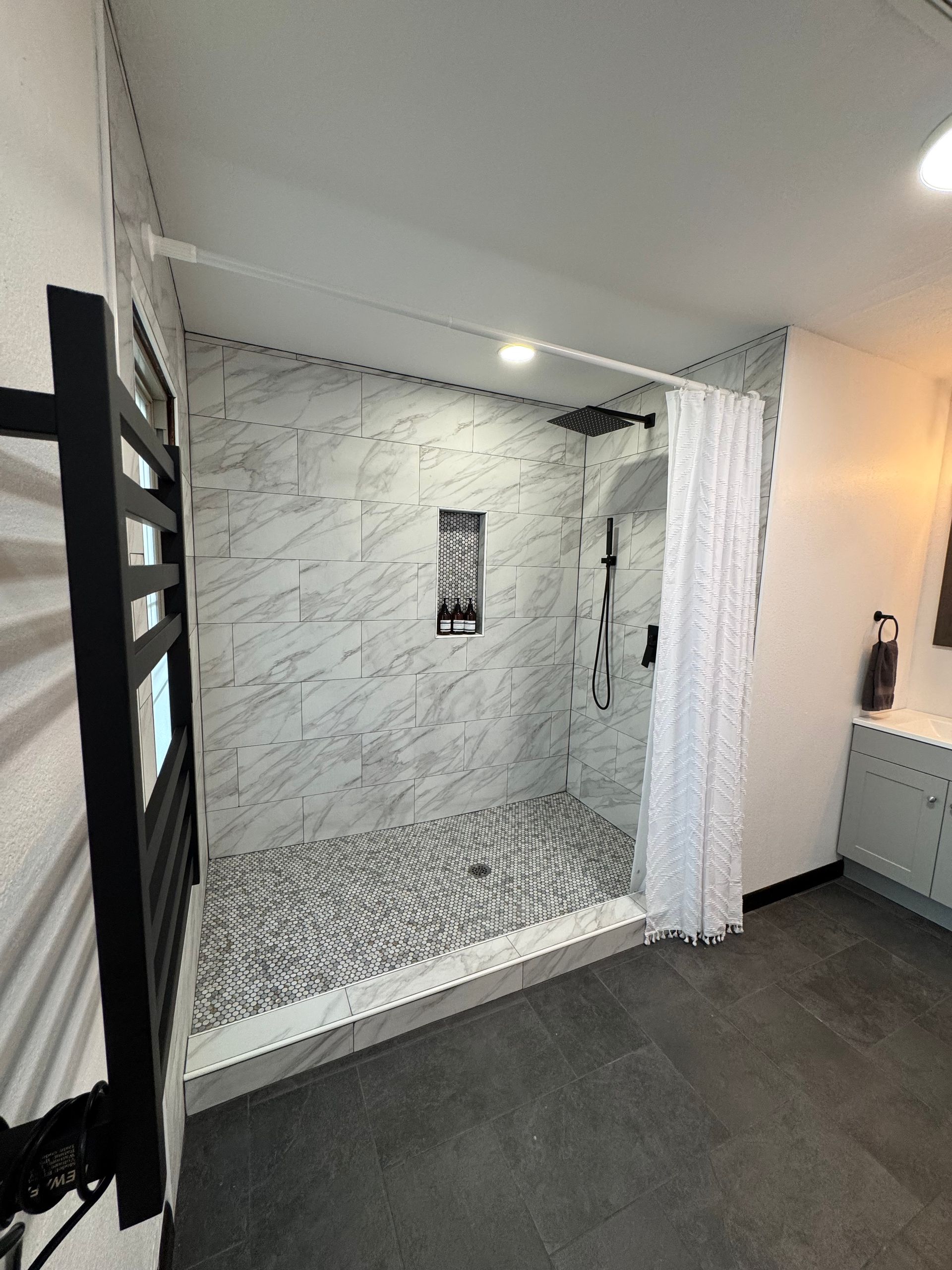 Primary bathroom with large walk in shower and towel warmer at Hilltop House Serenity Ridge