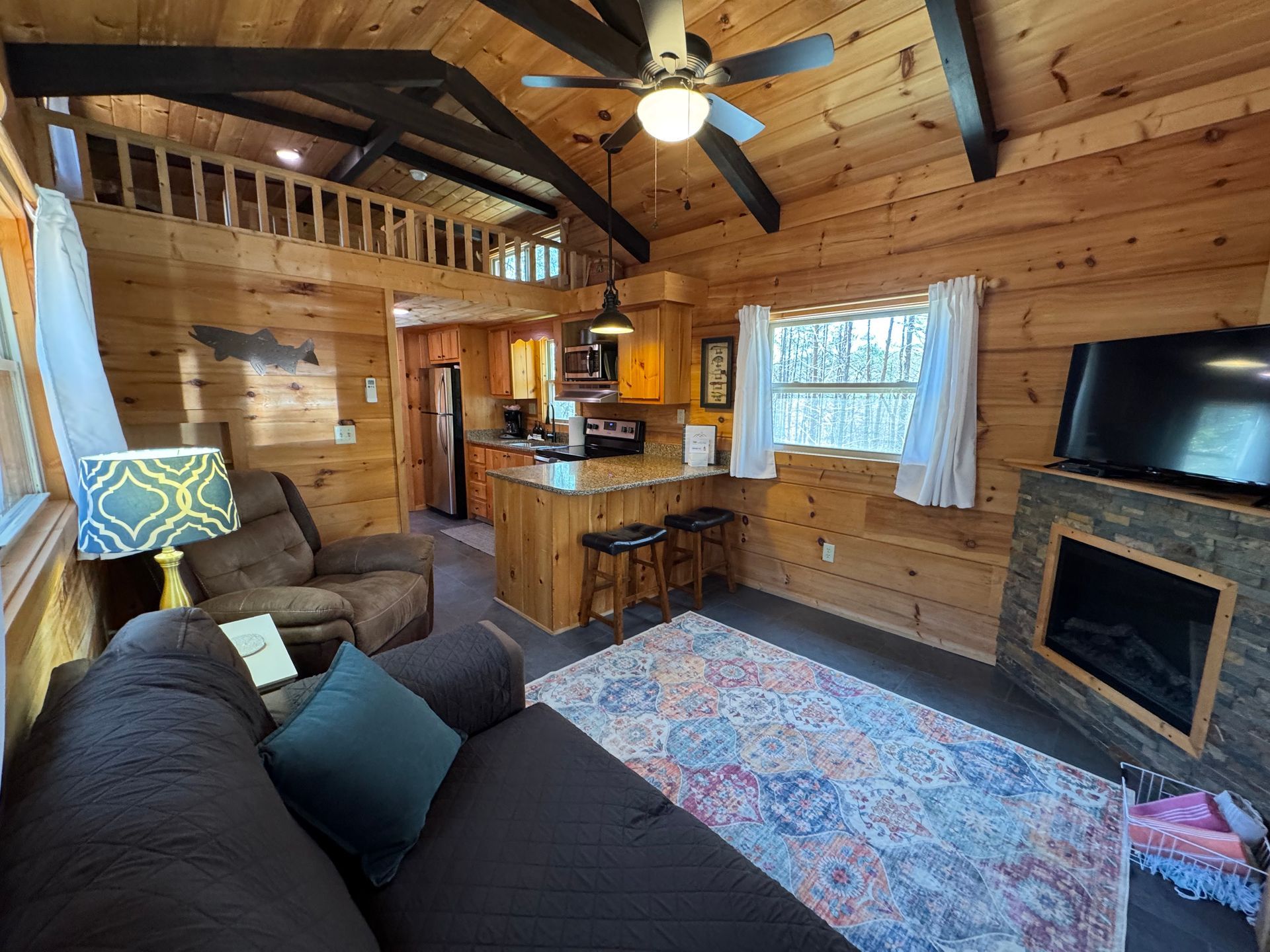 Living room facing kitchen counter seating in Cabin F at Serenity Ridge