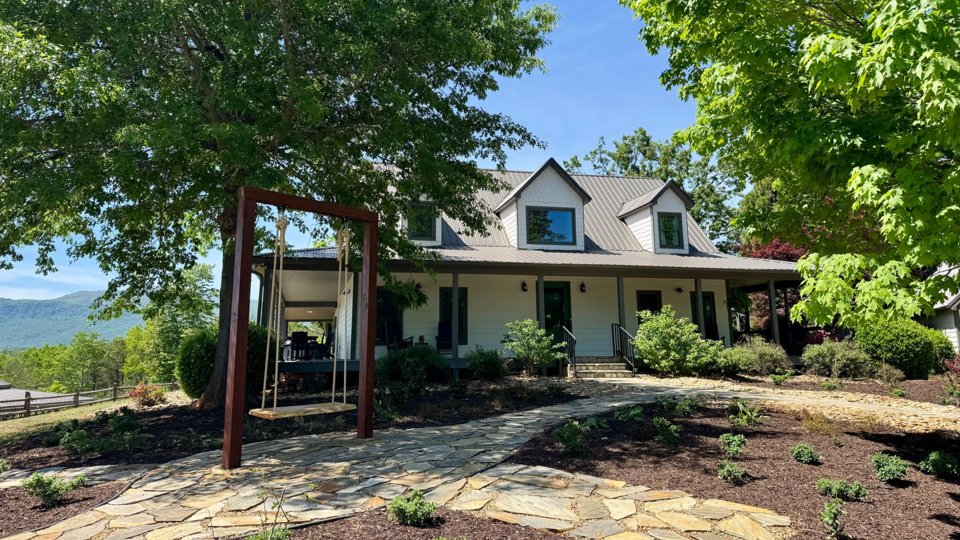 Hilltop House at Serenity Ridge, front view of home's gardens with NC mountains as backdrop