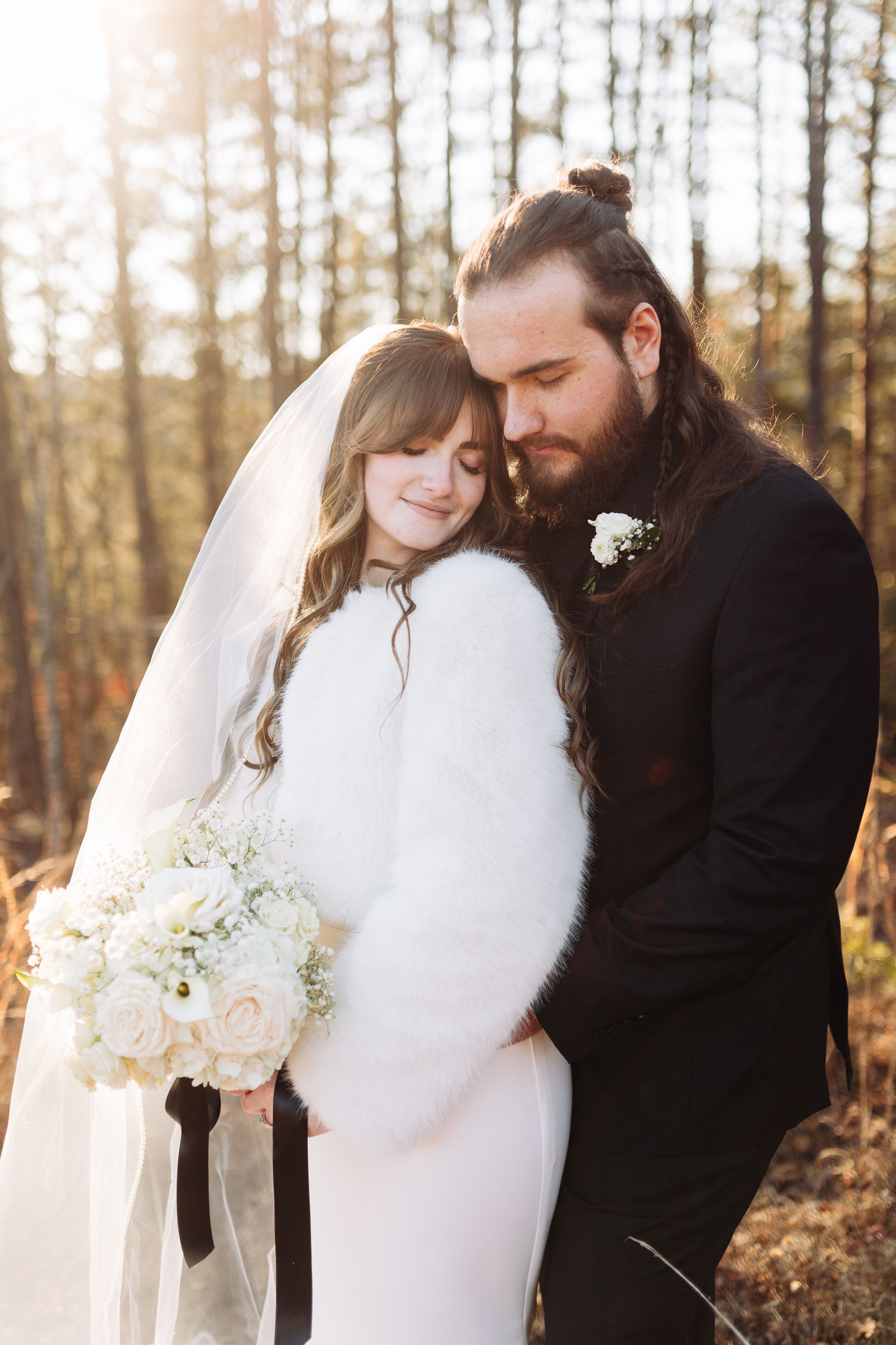 Bride and groom embracing in wooded setting during romantic mountain wedding portrait session