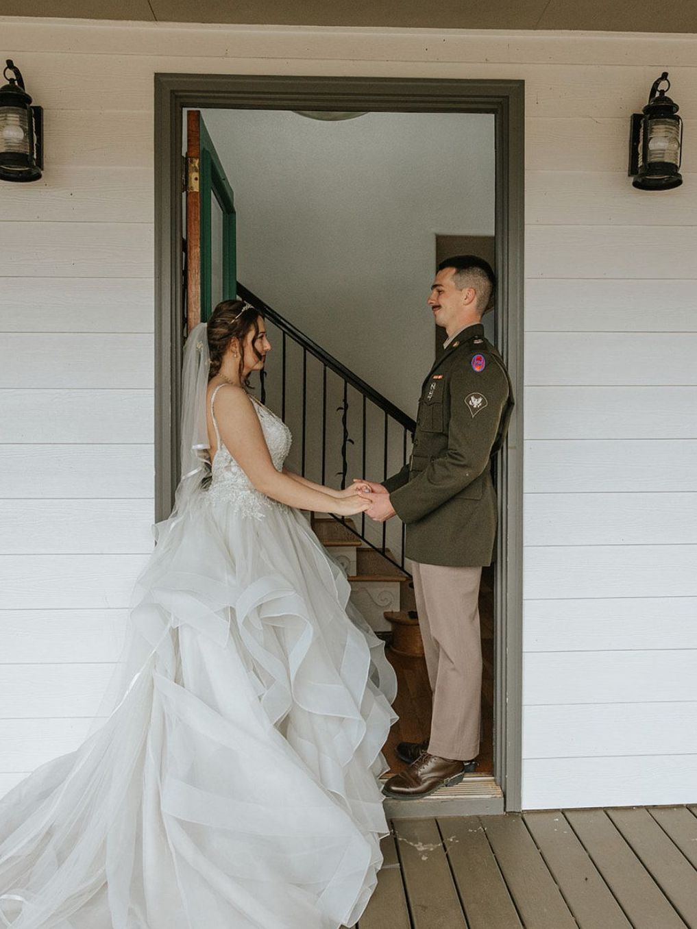 Couple standing happily in the doorway of Hilltop House at Serenity Ridge
