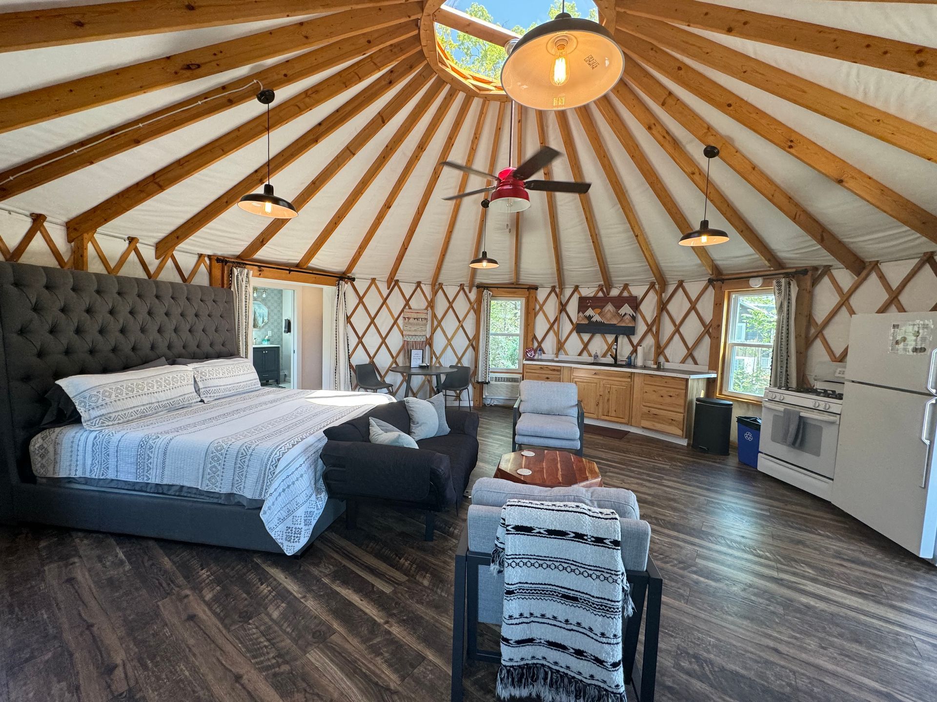 Open interior of glamping yurt with living and sleeping space at Serenity Ridge