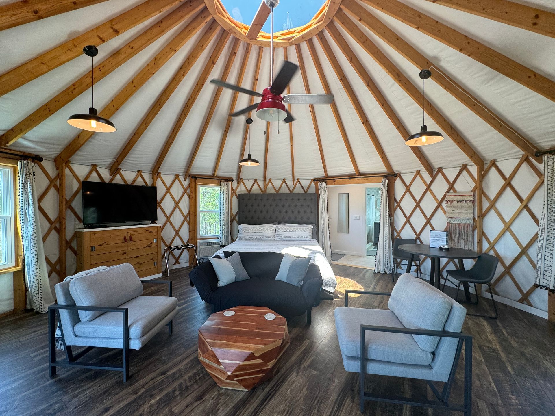 King bed under skylight inside glamping yurt at Serenity Ridge