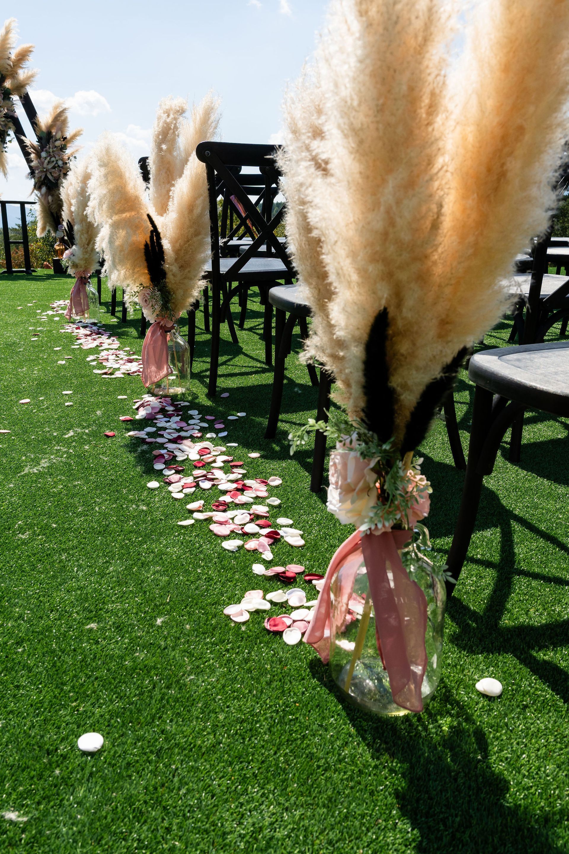 Outdoor ceremony aisle lined with pampas grass and mountain backdrop at NC wedding venue