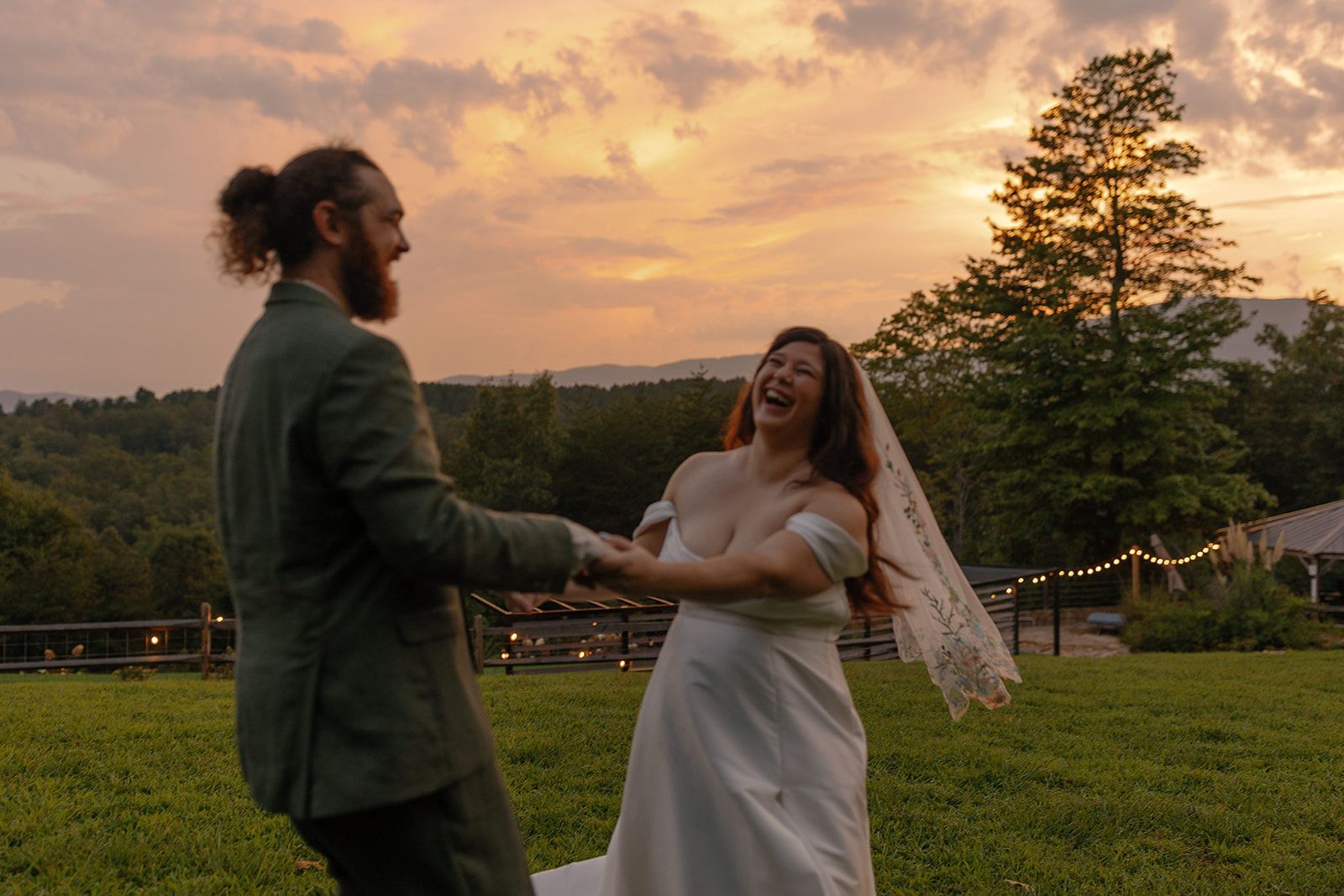 Bride and groom dancing together at sunset during outdoor mountain wedding celebration in North Carolina