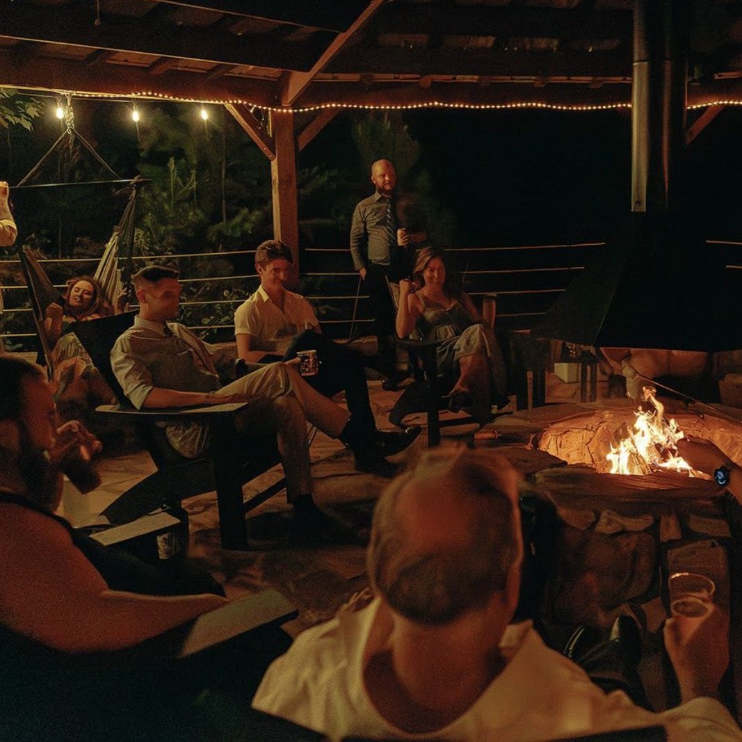 Wedding guests enjoying Friday night around the fire pavilion at Serenity Ridge mountain wedding venue in North Carolina