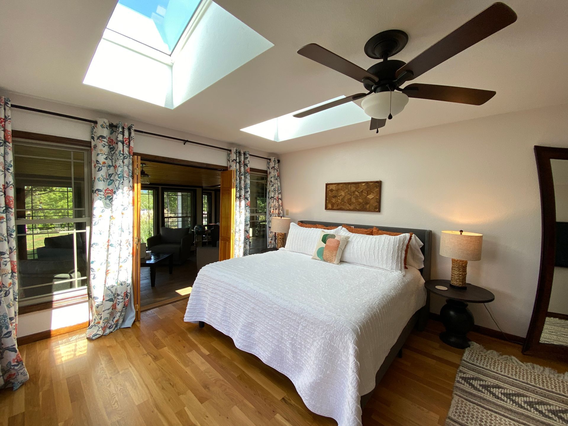 King bed under skylights in primary bedroom at Hilltop House Serenity Ridge