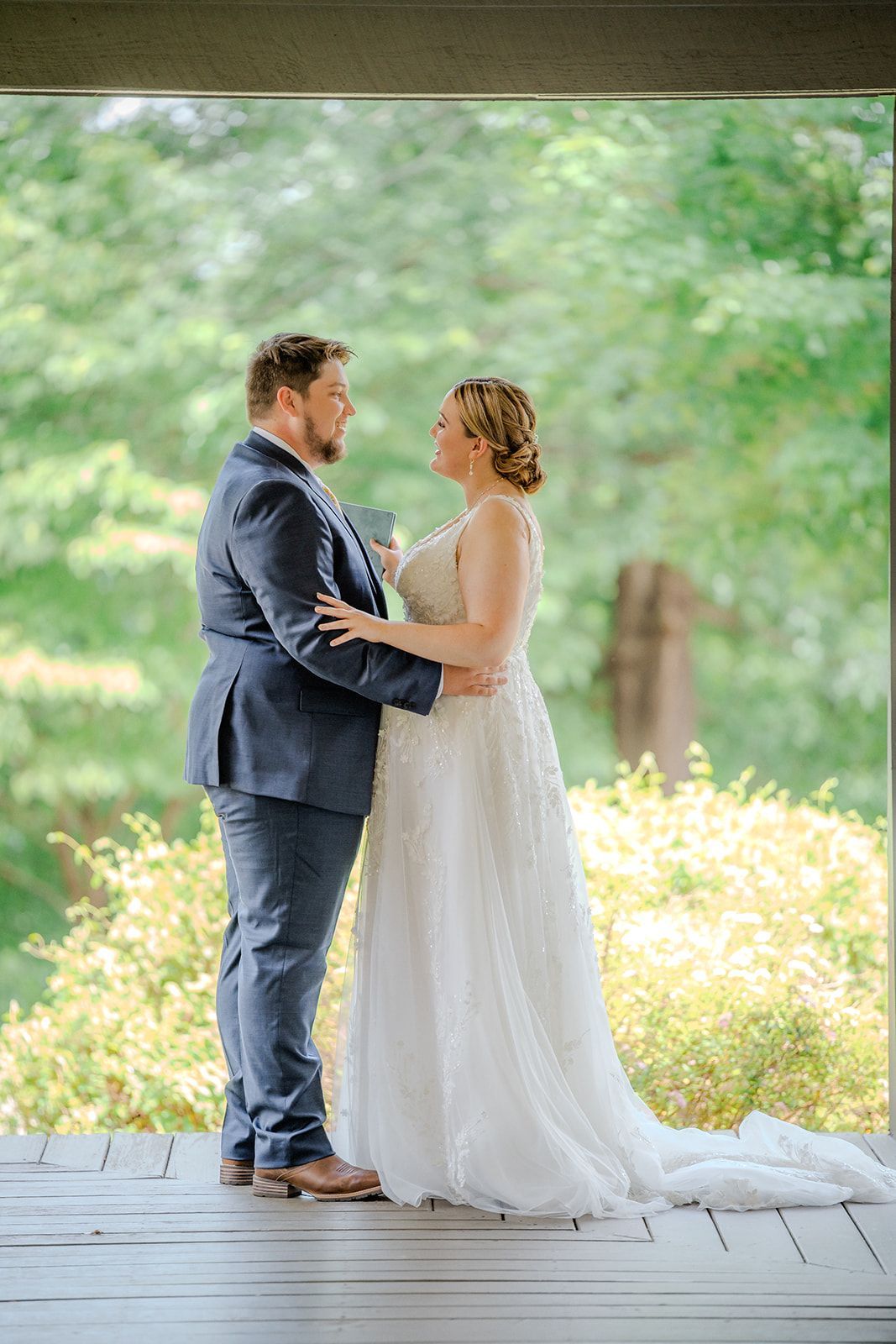 Bride and groom standing together beneath pavilion during elegant wedding weekend celebration