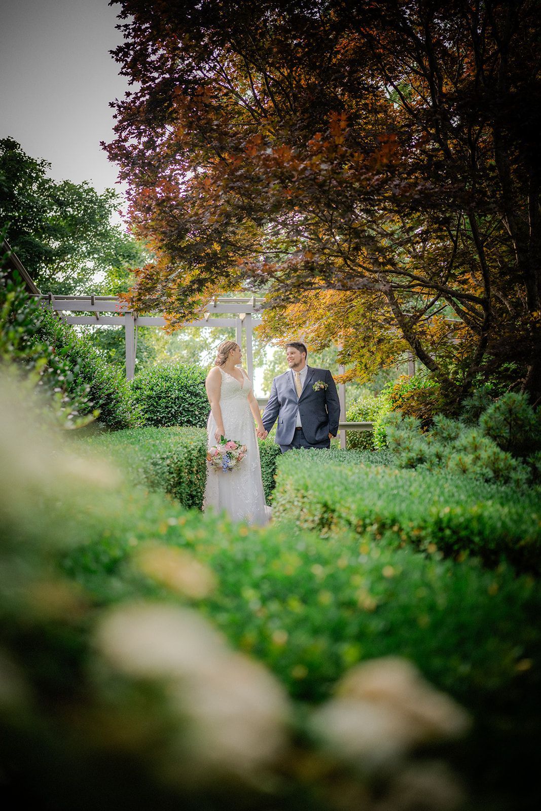 Bride and groom surrounded by lush garden scenery at mountain wedding venue in North Carolina