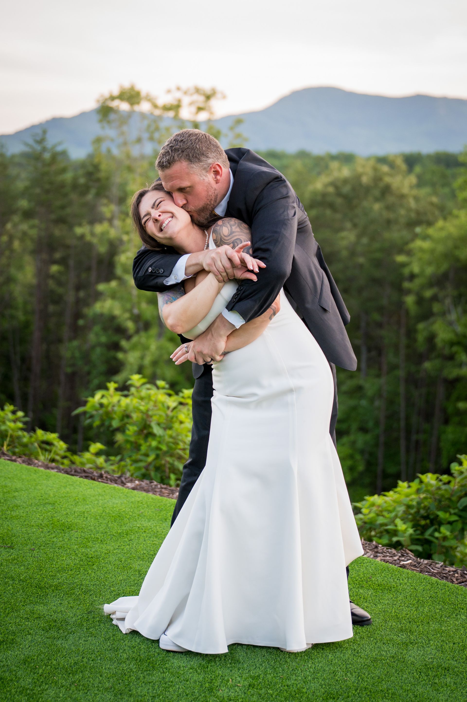 Bride and groom embracing with Blue Ridge mountain views during outdoor wedding portraits