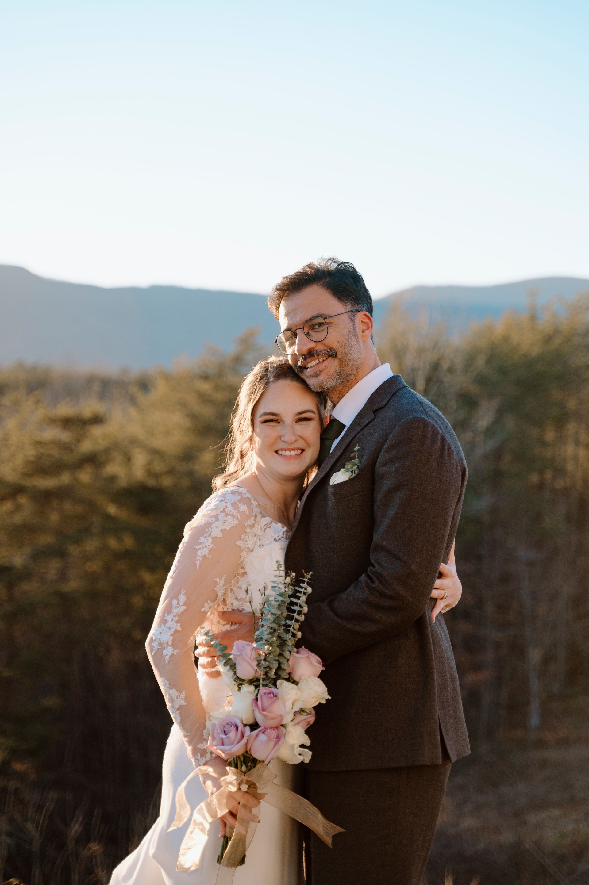Bride and groom smiling together with scenic mountain backdrop at North Carolina wedding venue