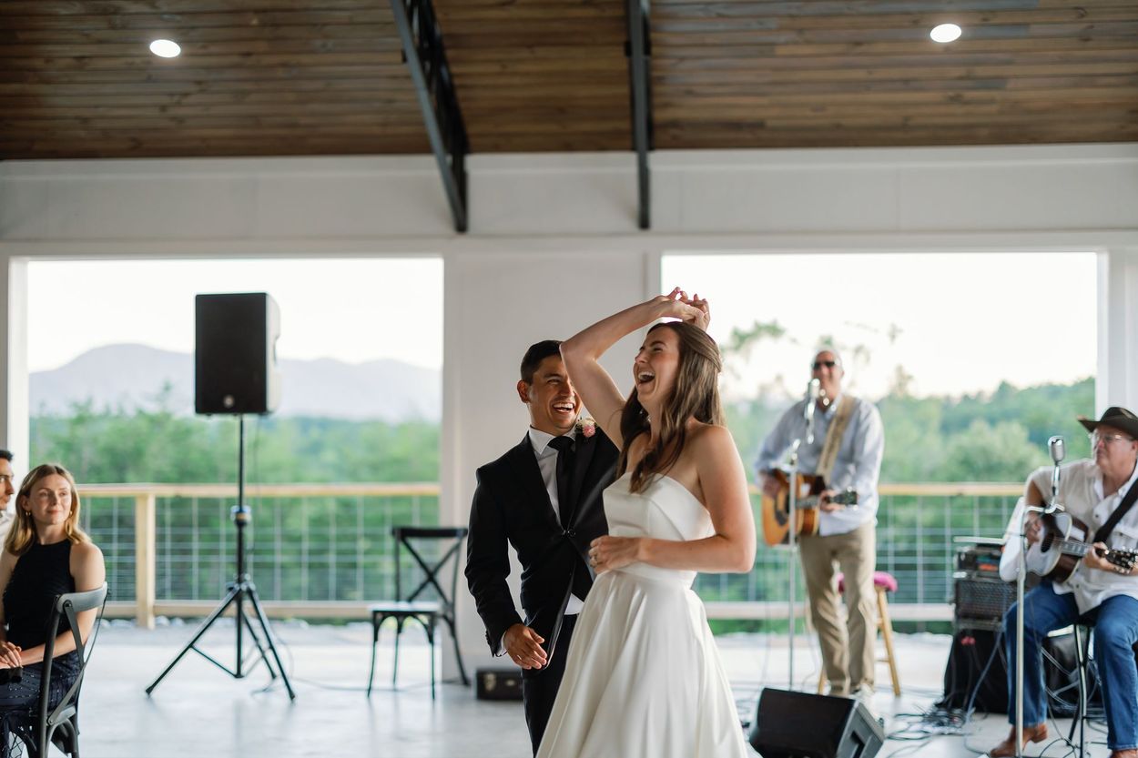 Couple dancing in Serenity Ridge’s event pavilion, live band playing and modern mountain charm.
