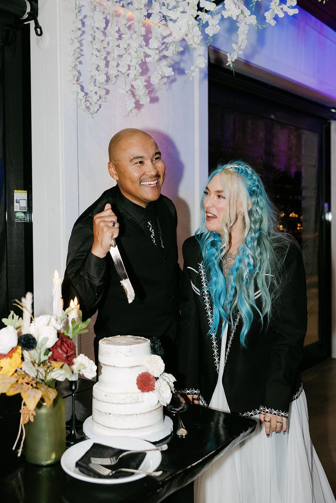 Bride and groom cutting wedding cake during reception celebration at mountain venue