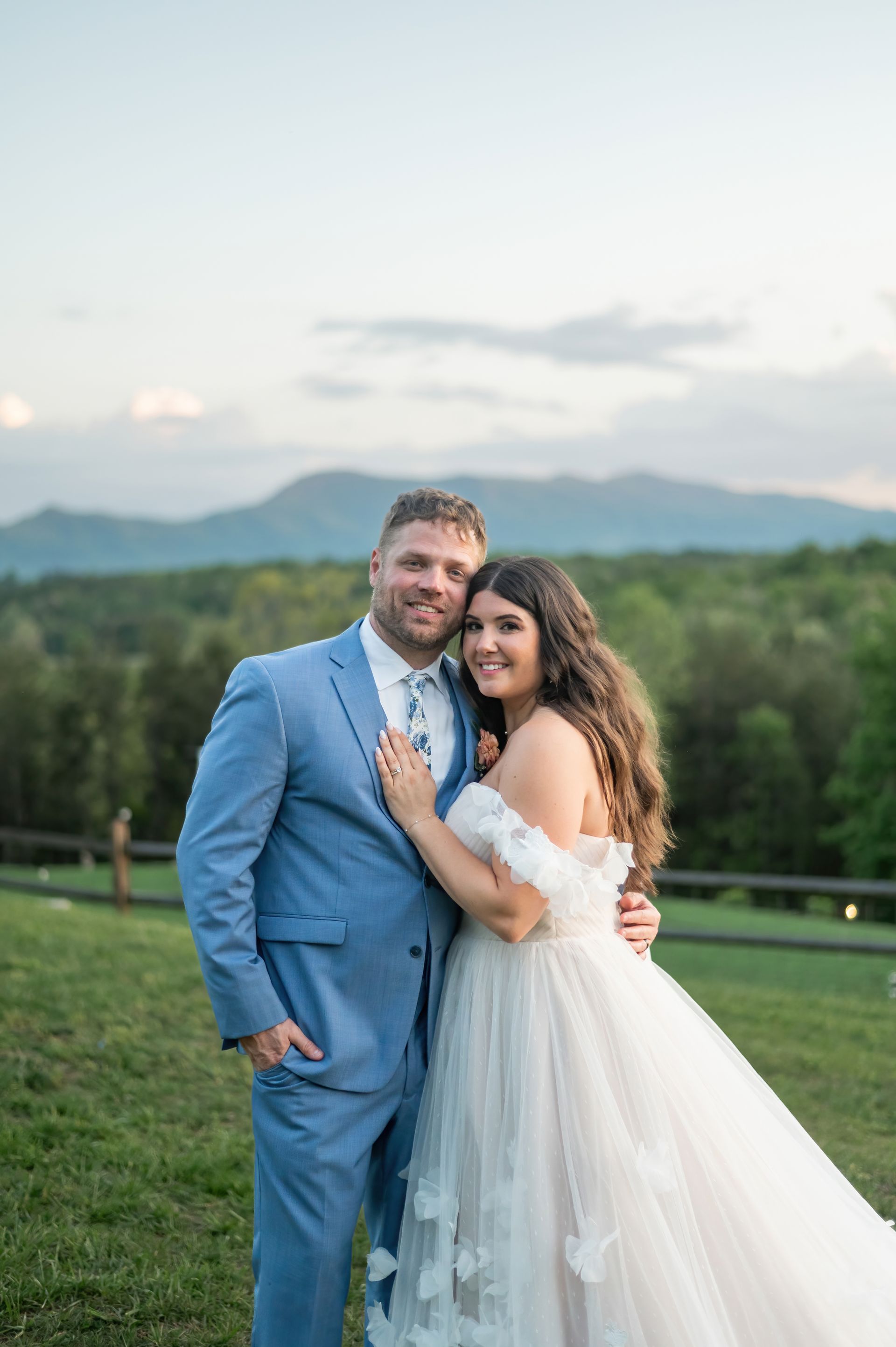 Bride and groom smiling together with panoramic mountain views at western North Carolina wedding venue