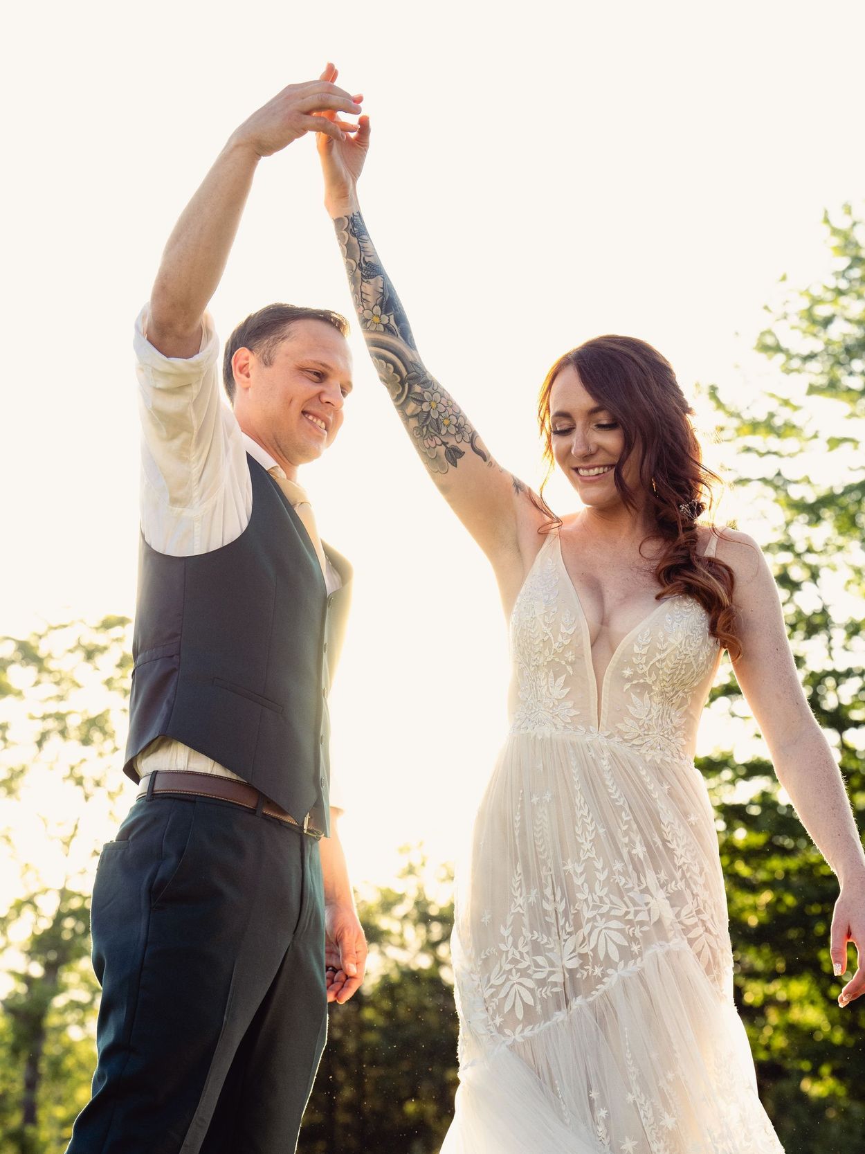 Couple dancing bathed in golden hour sunlight at Serenity Ridge, surrounded by nature
