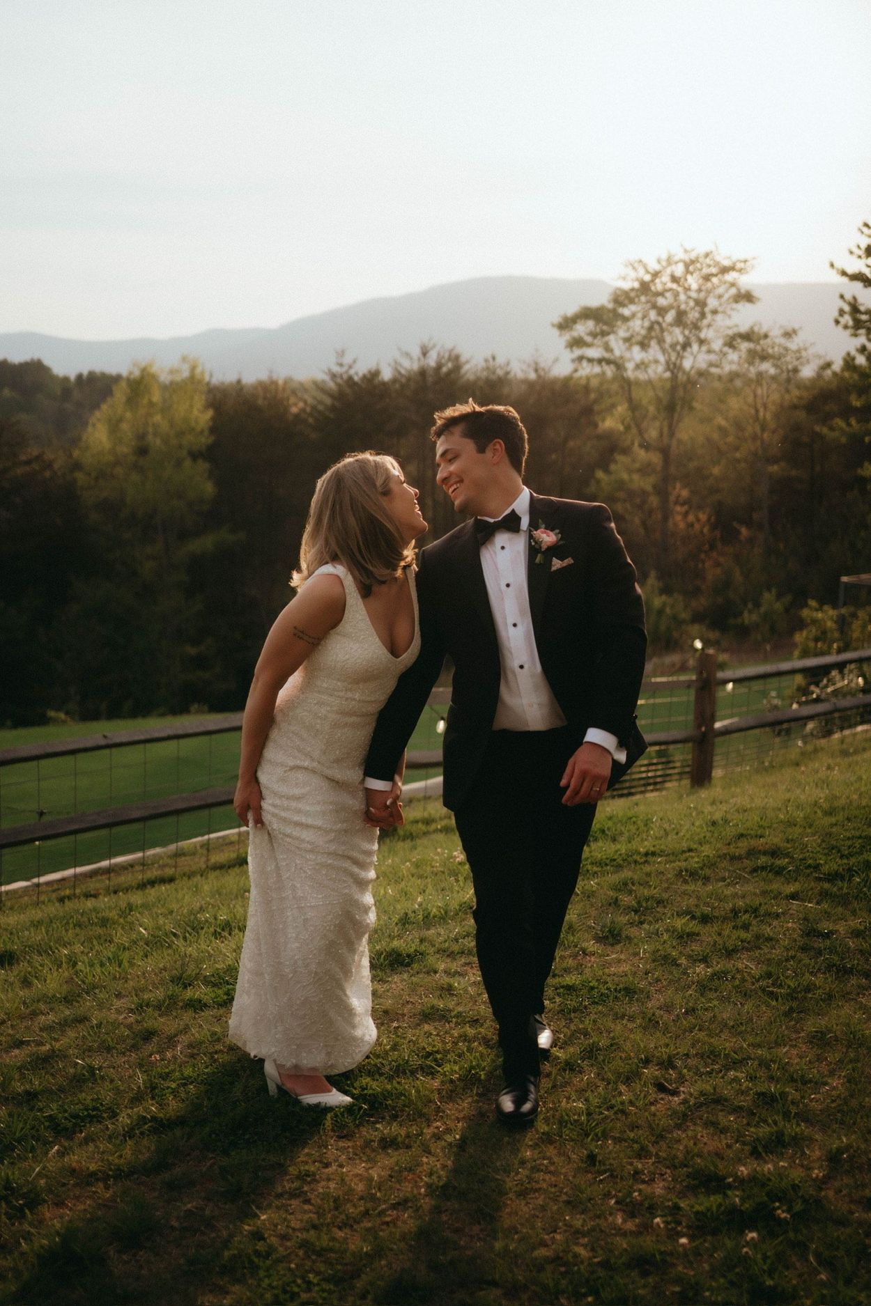 Couple walking hand in hand, laughing joyfully at Serenity Ridge with mountain views.