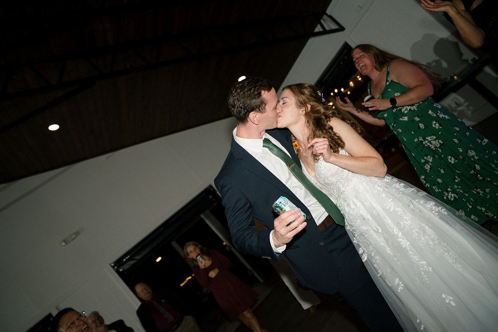 Guests dancing at lively wedding reception in open-air pavilion at mountain wedding venue