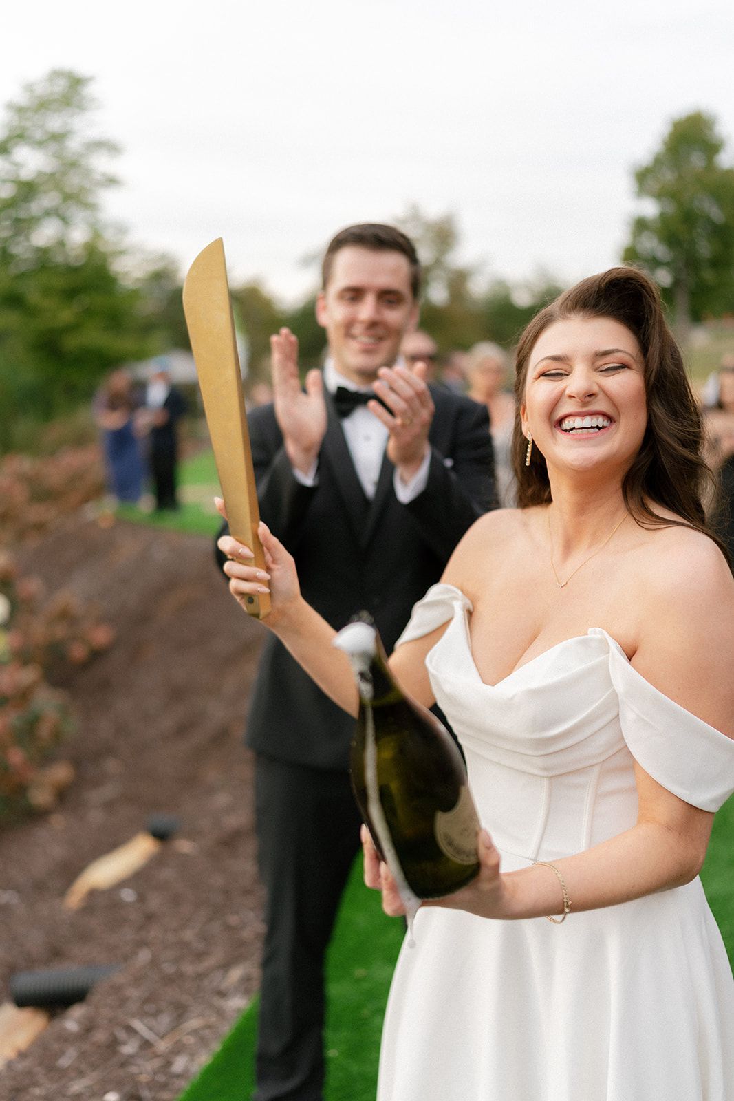 Bride celebrating with champagne pop during outdoor wedding festivities at mountain venue